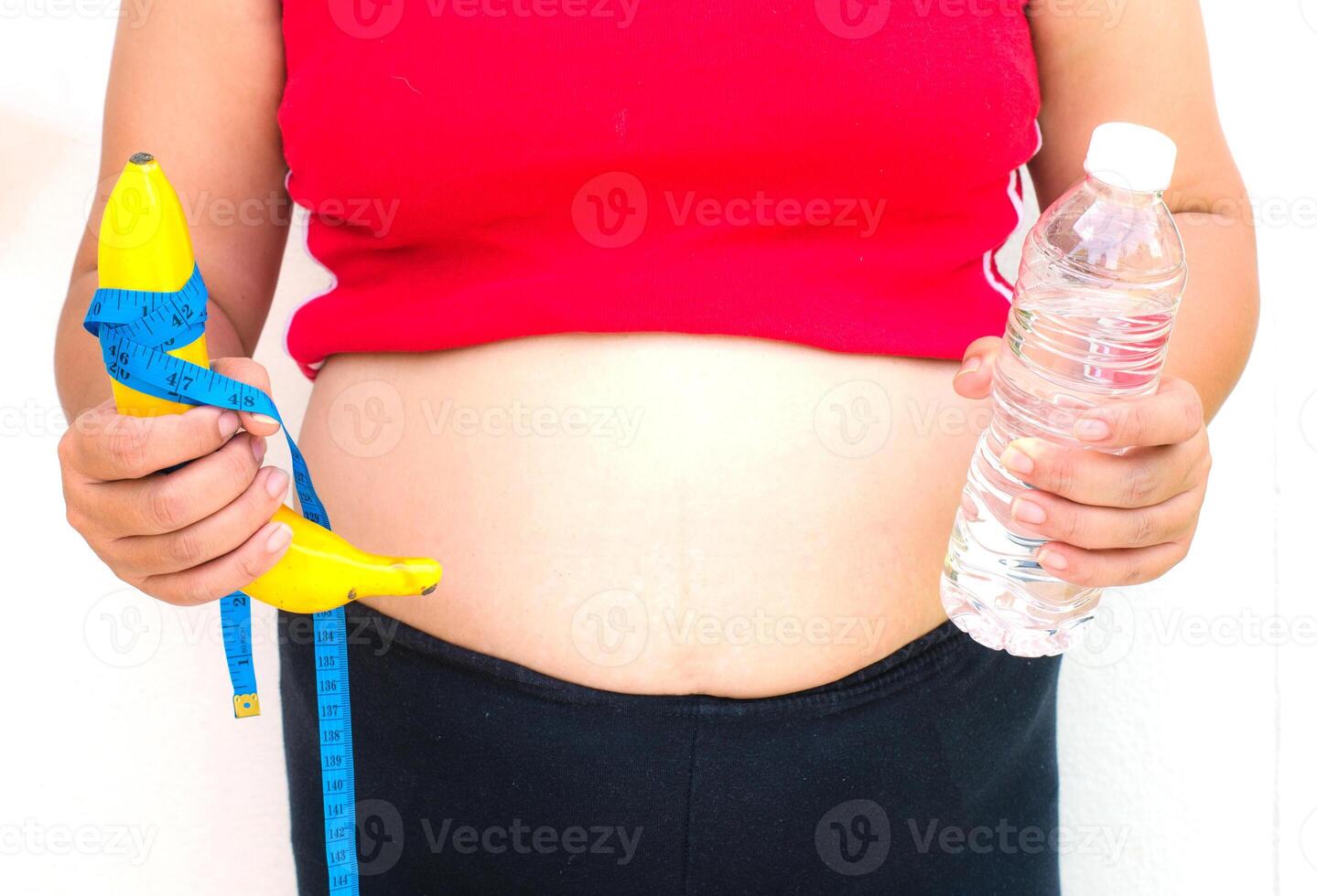 The concept of diet for weight loss - Fat women in hand have fruit and water. photo
