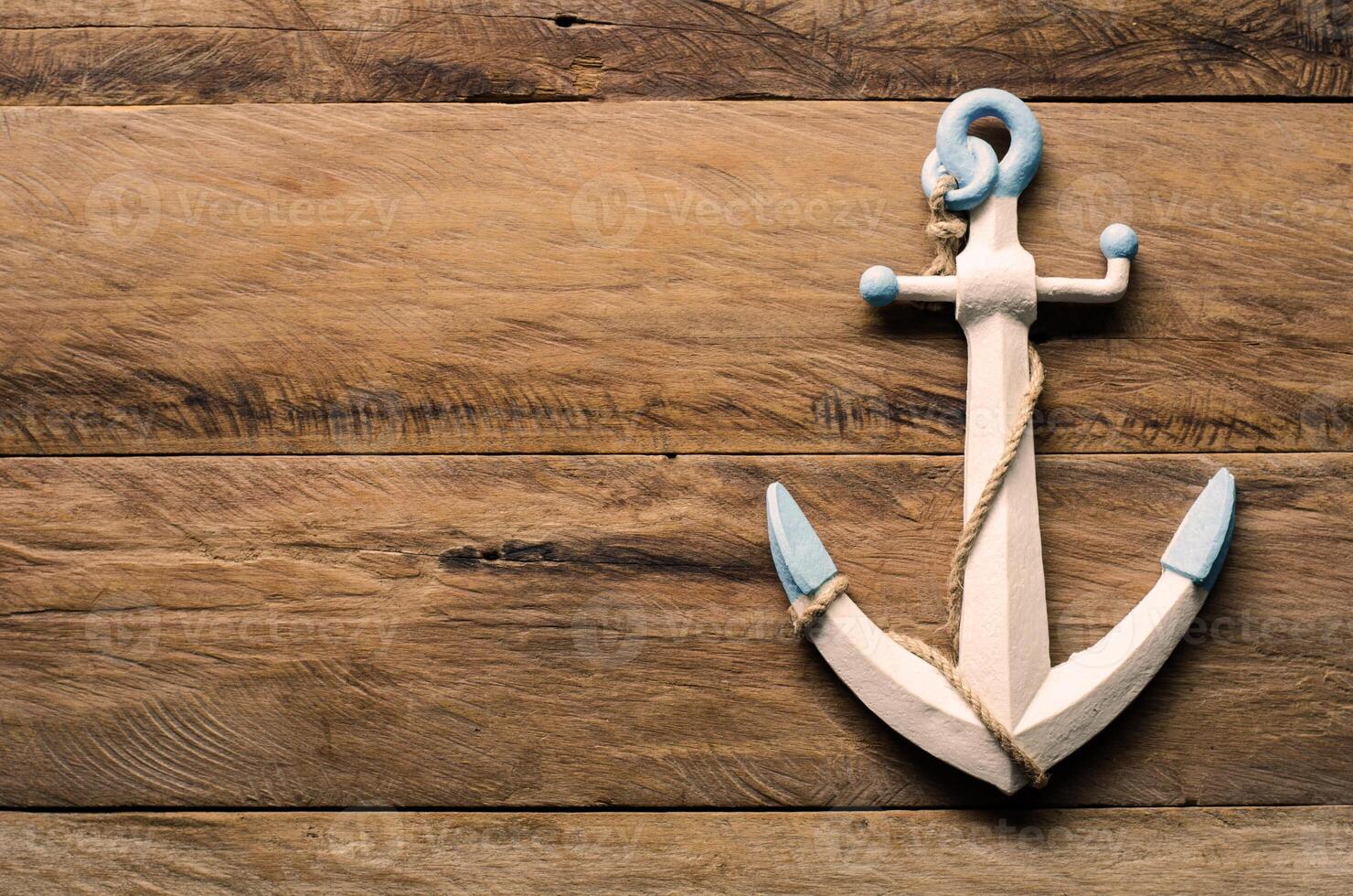 The white anchor is placed on a wooden floor. photo