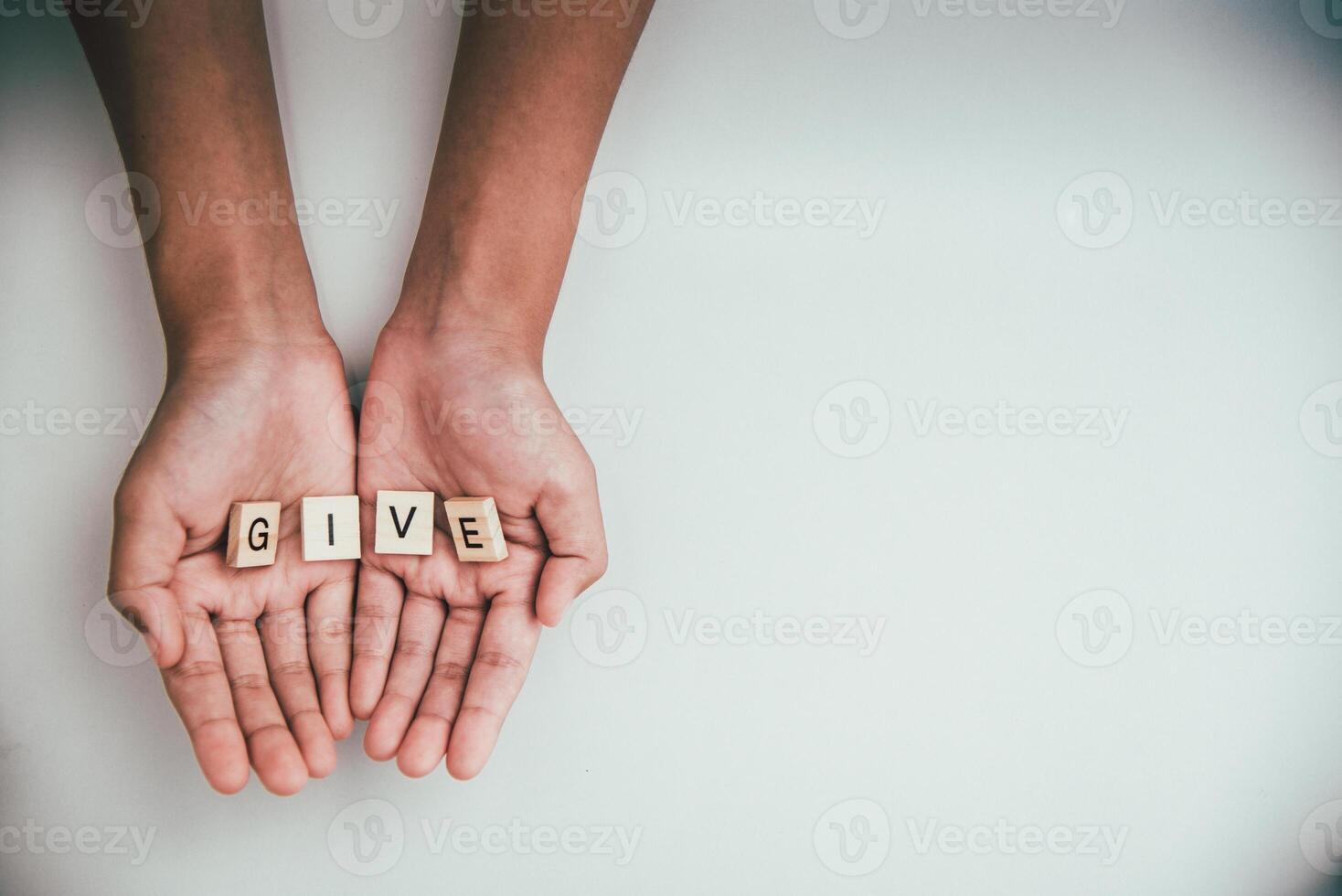 The word  GIVE  in hands in cupped shape. Concepts of sharing, giving, photo