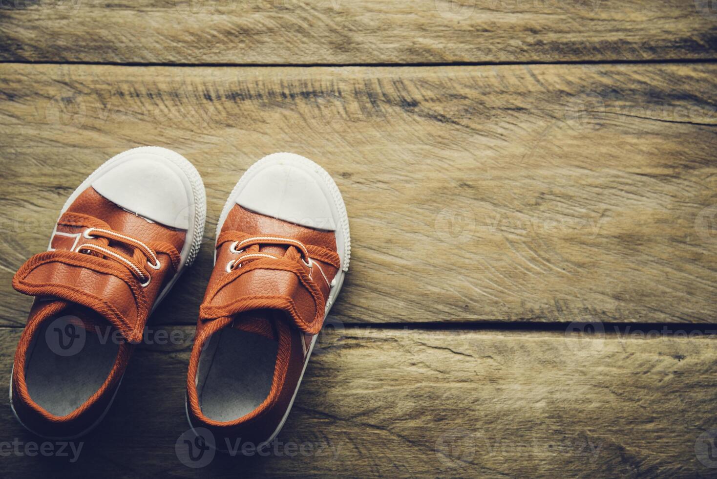 rojo Zapatos para niños en de madera piso foto