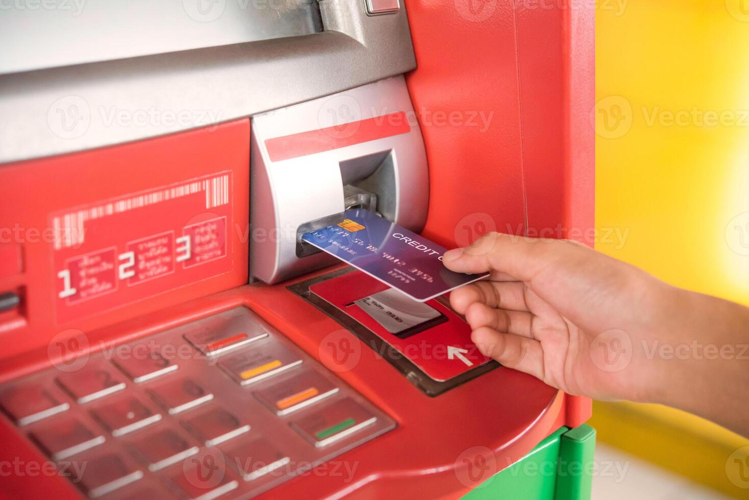 Hand inserting with a credit card into bank machine . Man using an atm machine with  credit card to withdraw money photo