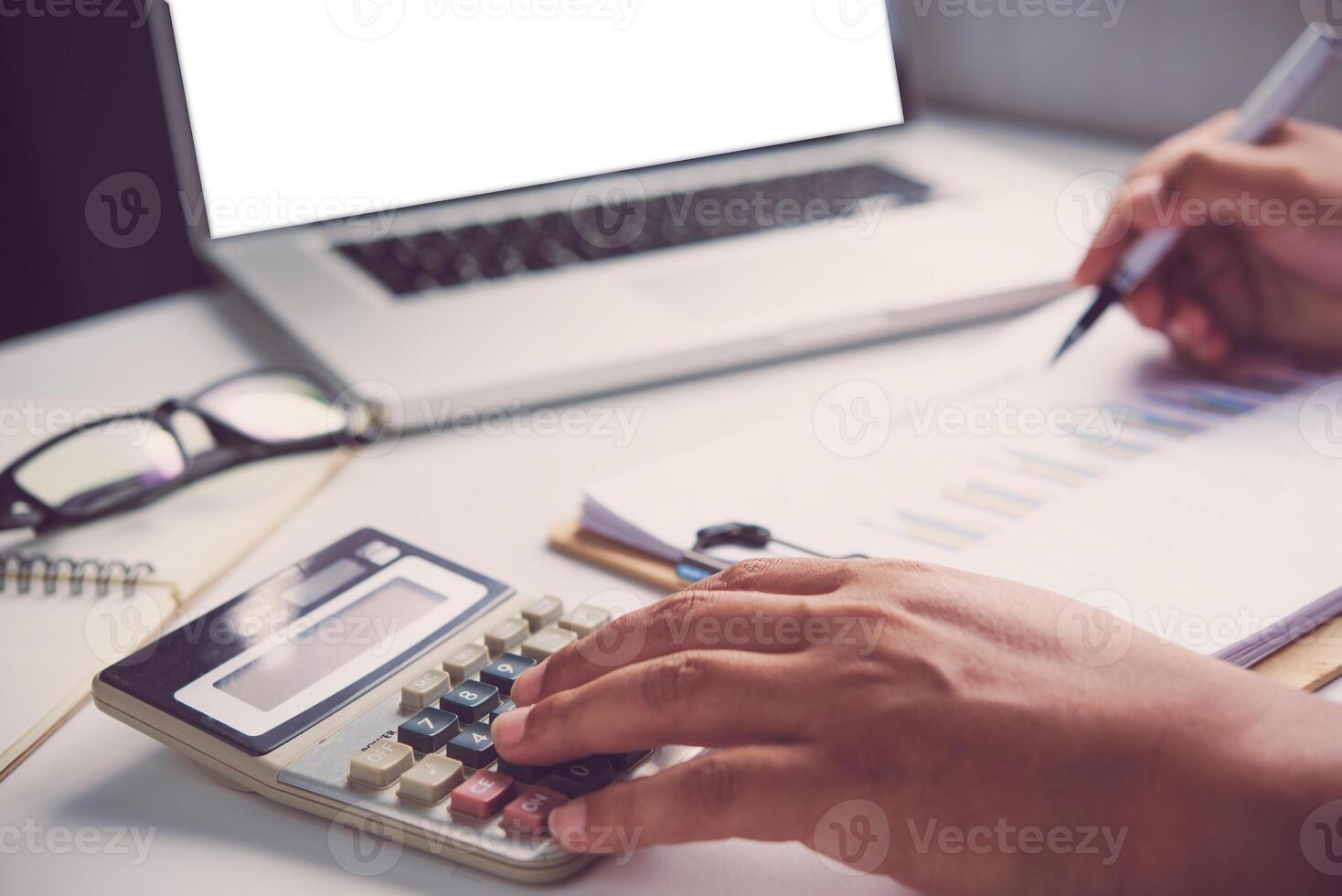 Businessmen are using a calculator to calculate the income of the business. photo