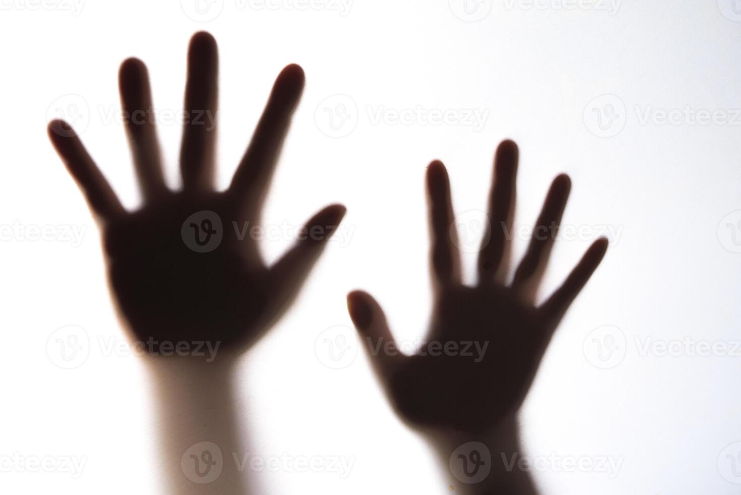 The silhouette of a woman's hand expressing fear. photo