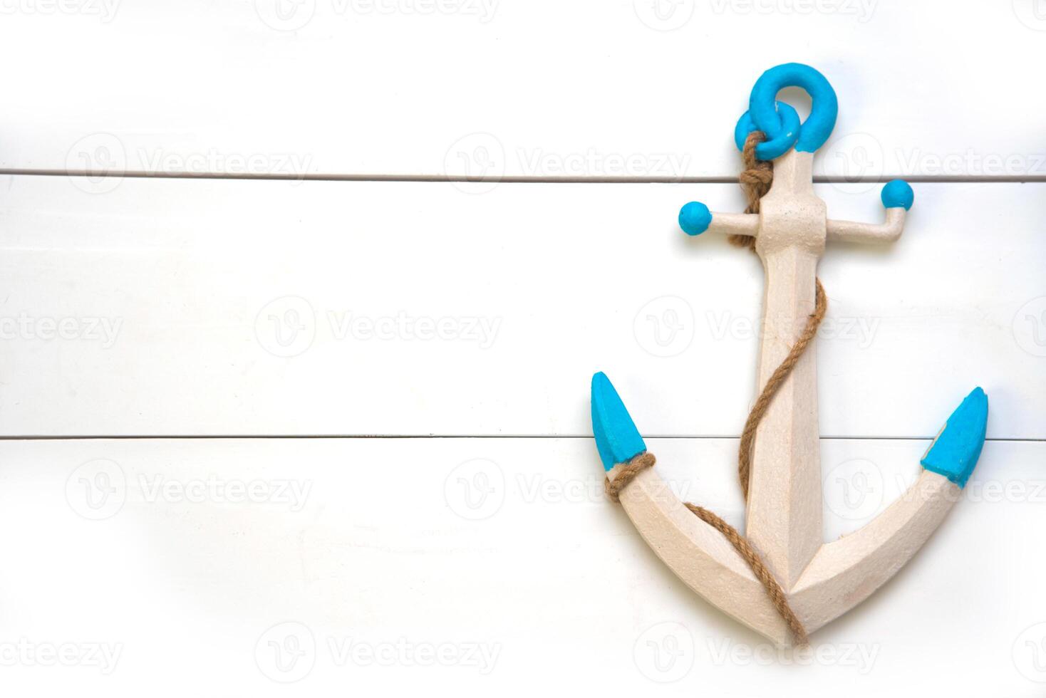 The anchor is placed on a white wooden floor. photo