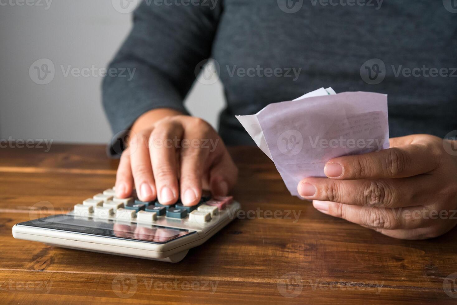 Hand on calculator to calculate cost based on holding bill. photo