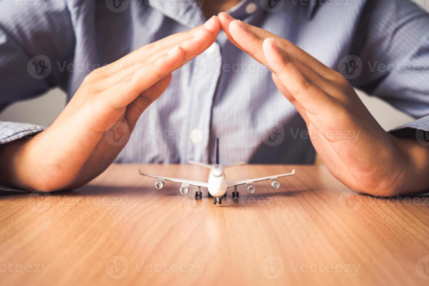 Hand protecting the icon a plane - the concept of insurance for travel photo