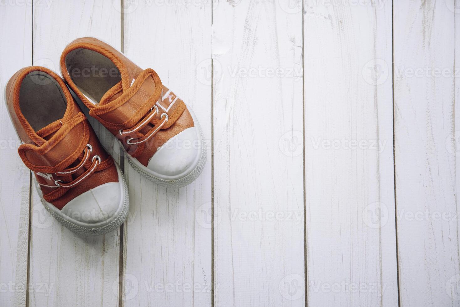 rojo Zapatos para niños en de madera piso foto