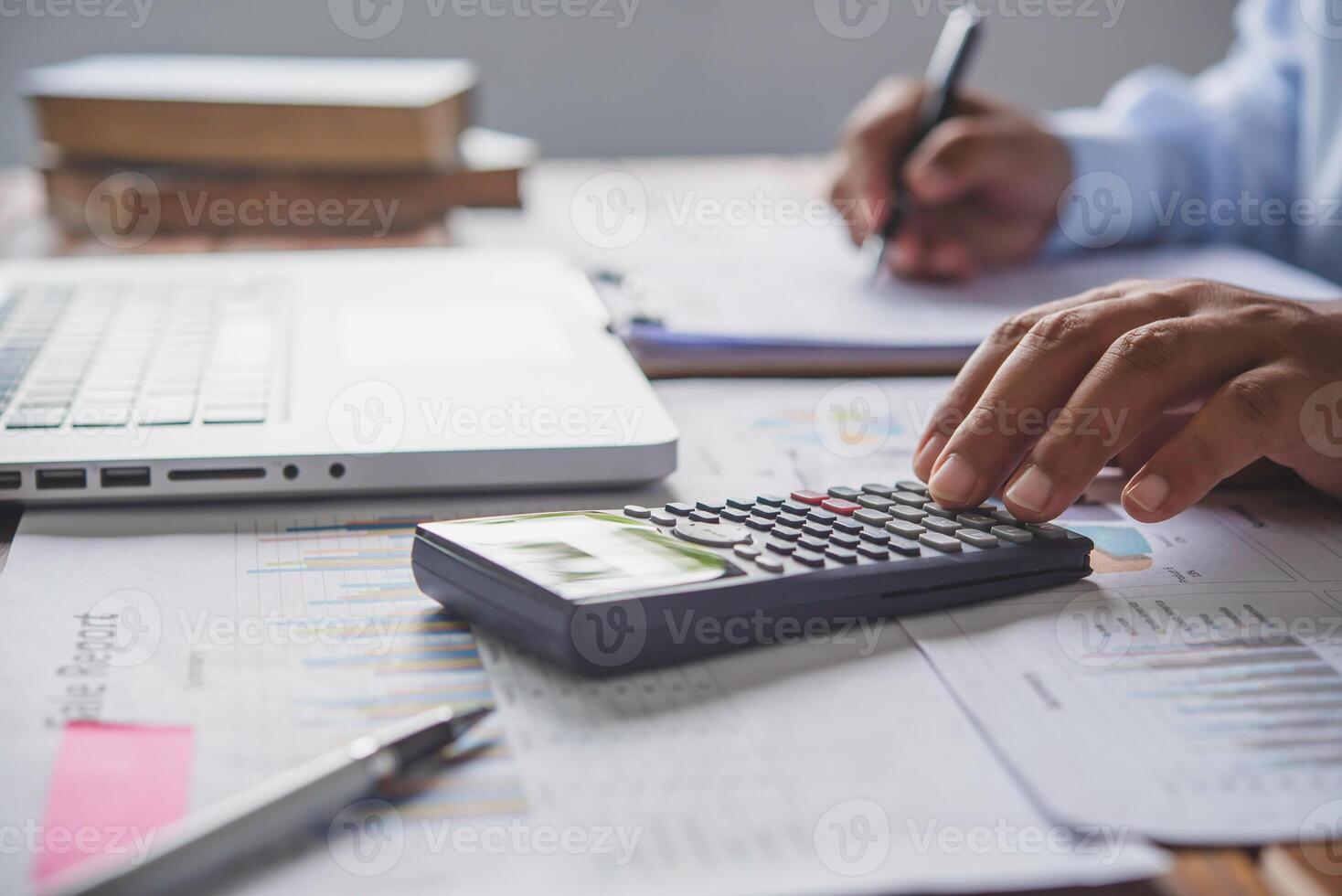 people are working with a calculator and laptop. in office business concept photo