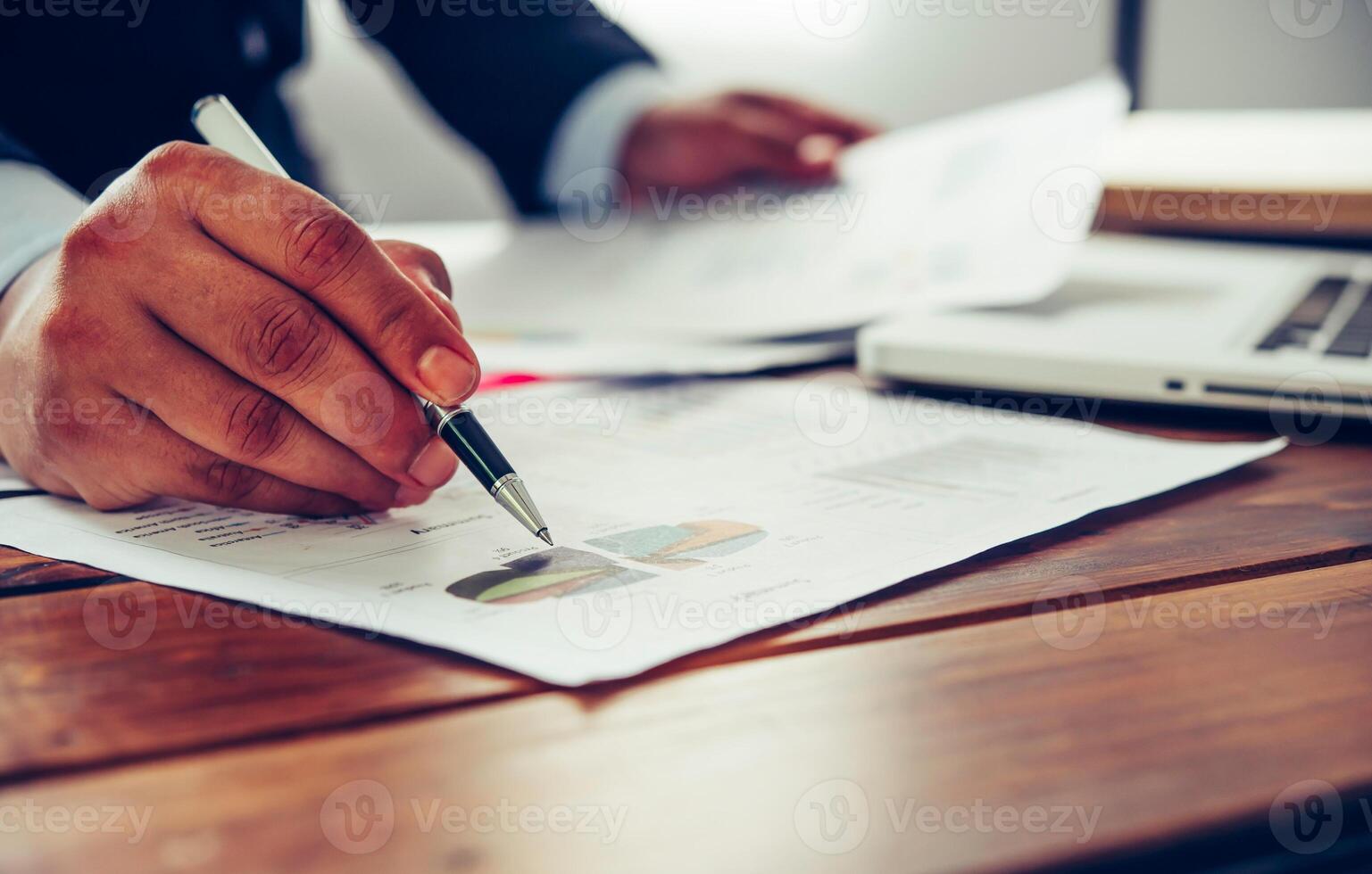 Business people are working on accounts in business analysis with graphs and documentation. photo