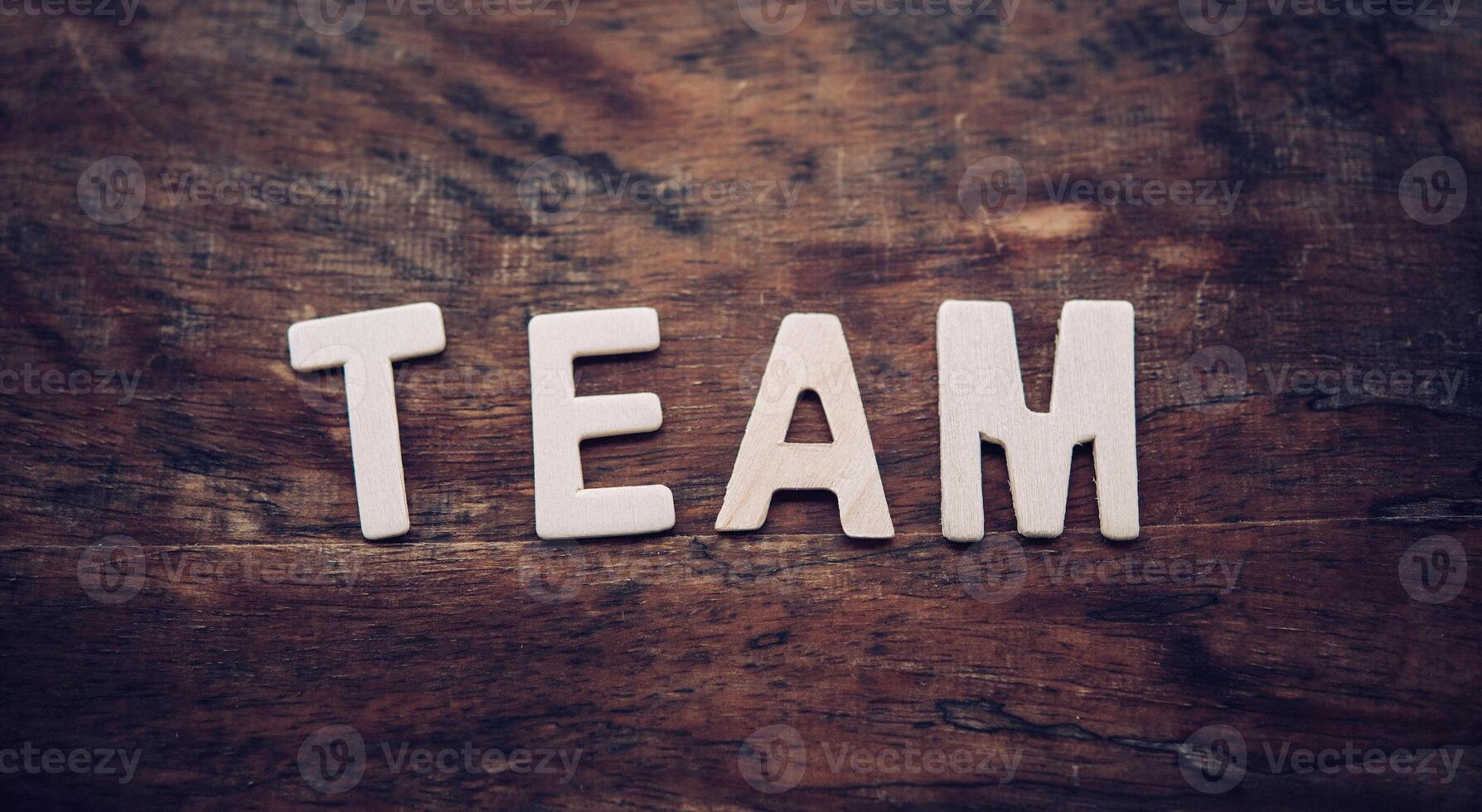 The word TEAM is arranged from a wooden letter placed on a wooden floor. photo