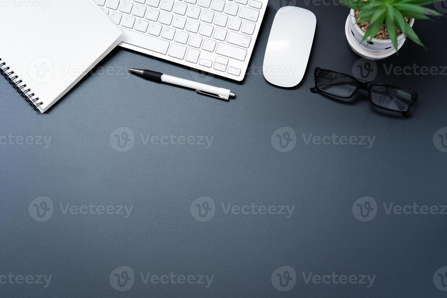 Top view with laptop, mobile phone, coffee cup, pencil, pencil and glasses placed on a black background photo