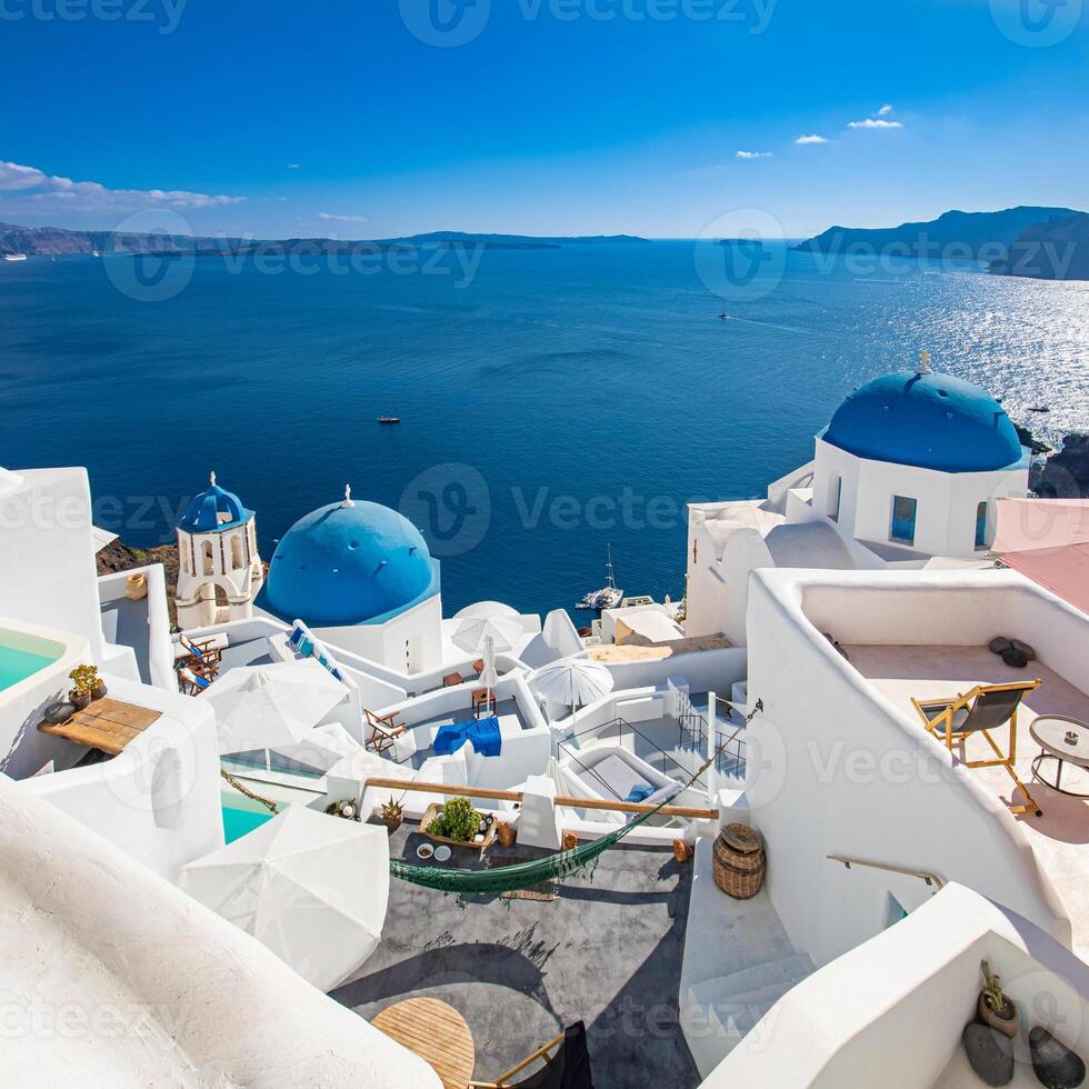 Famous blue dome churches in Oia, Santorini, Greece in the morning. White architecture of Oia village on Santorini island, Greece. Traditional tourism in mediterranean white architecture view photo