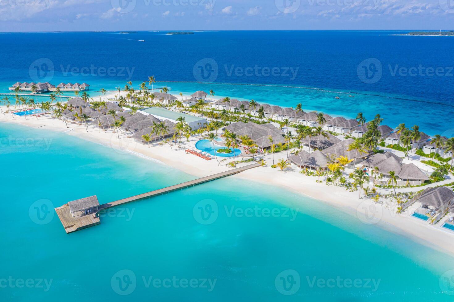 hermosa vista aérea de la playa junto a la piscina y del resort con embarcadero de madera. lujoso paisaje de playa tropical, natación, tumbonas y tumbonas, sombrillas. playa tropical, vista superior de drones aéreos foto