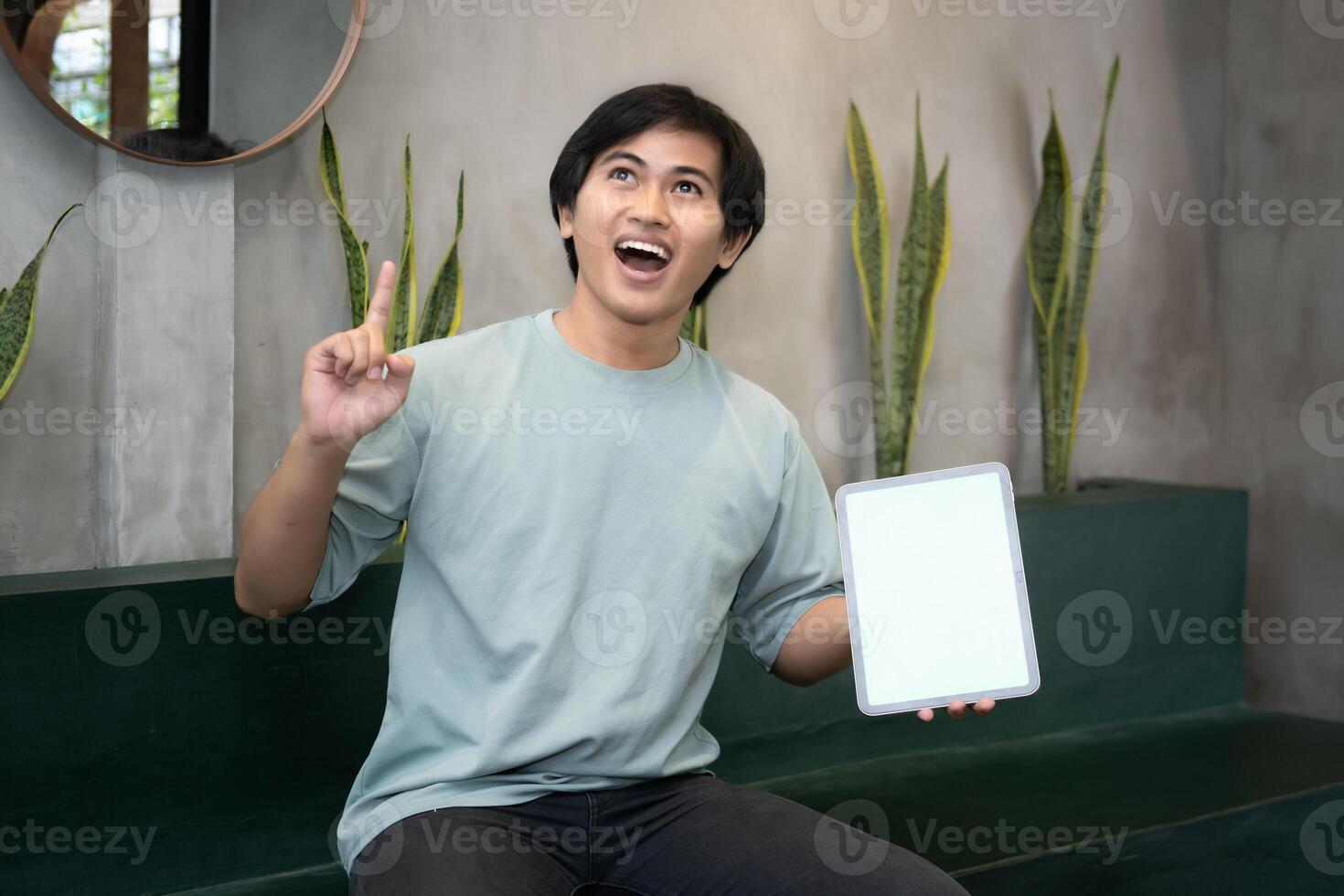 Potrait of Young Asian men holding a tablet PC in a cafe workplace with expressive faces photo