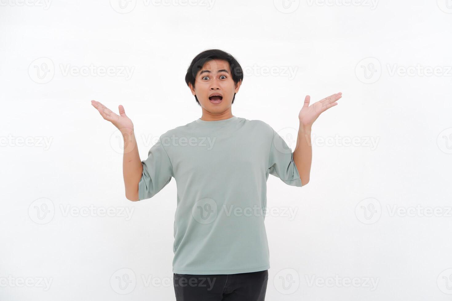 A young Asian man raises his hand with a confused and clueless expression photo