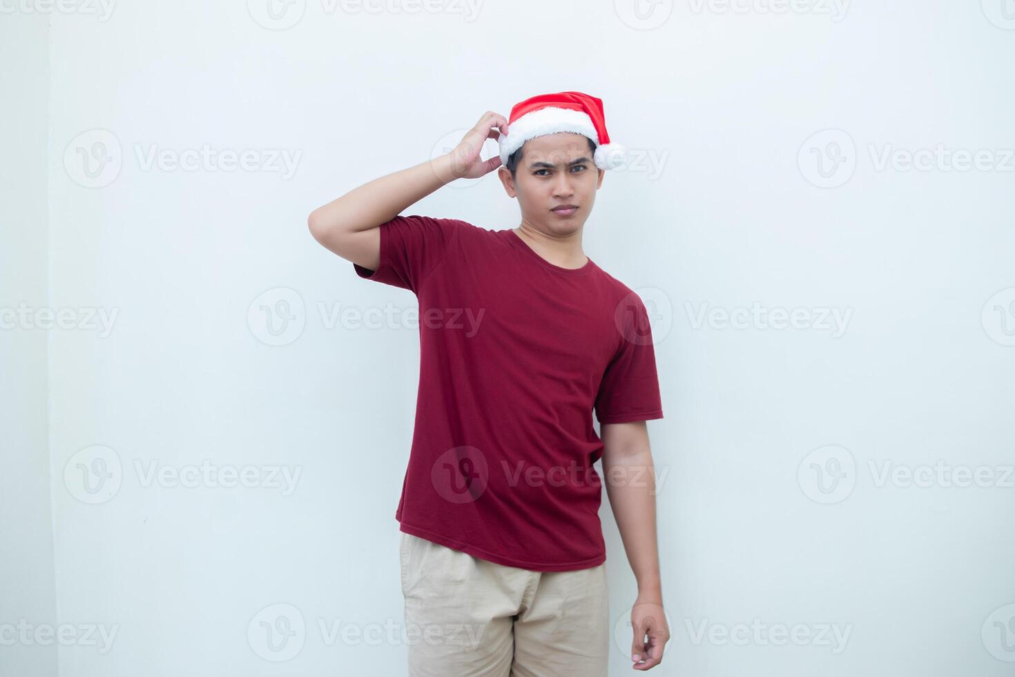 joven asiático hombre vistiendo un Papa Noel claus sombrero expresando confusión, pensamiento, y luego teniendo un idea, aislado por un blanco antecedentes para visual comunicación foto