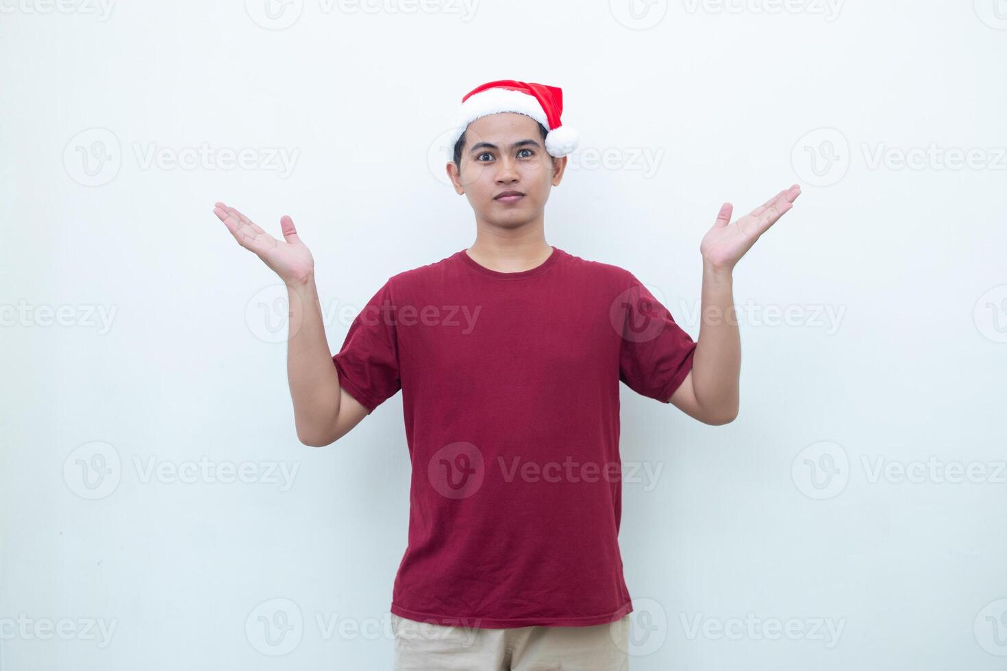 Young Asian man wearing a Santa Claus hat smiling, shock and pointing to her side isolated by white background for visual communication photo