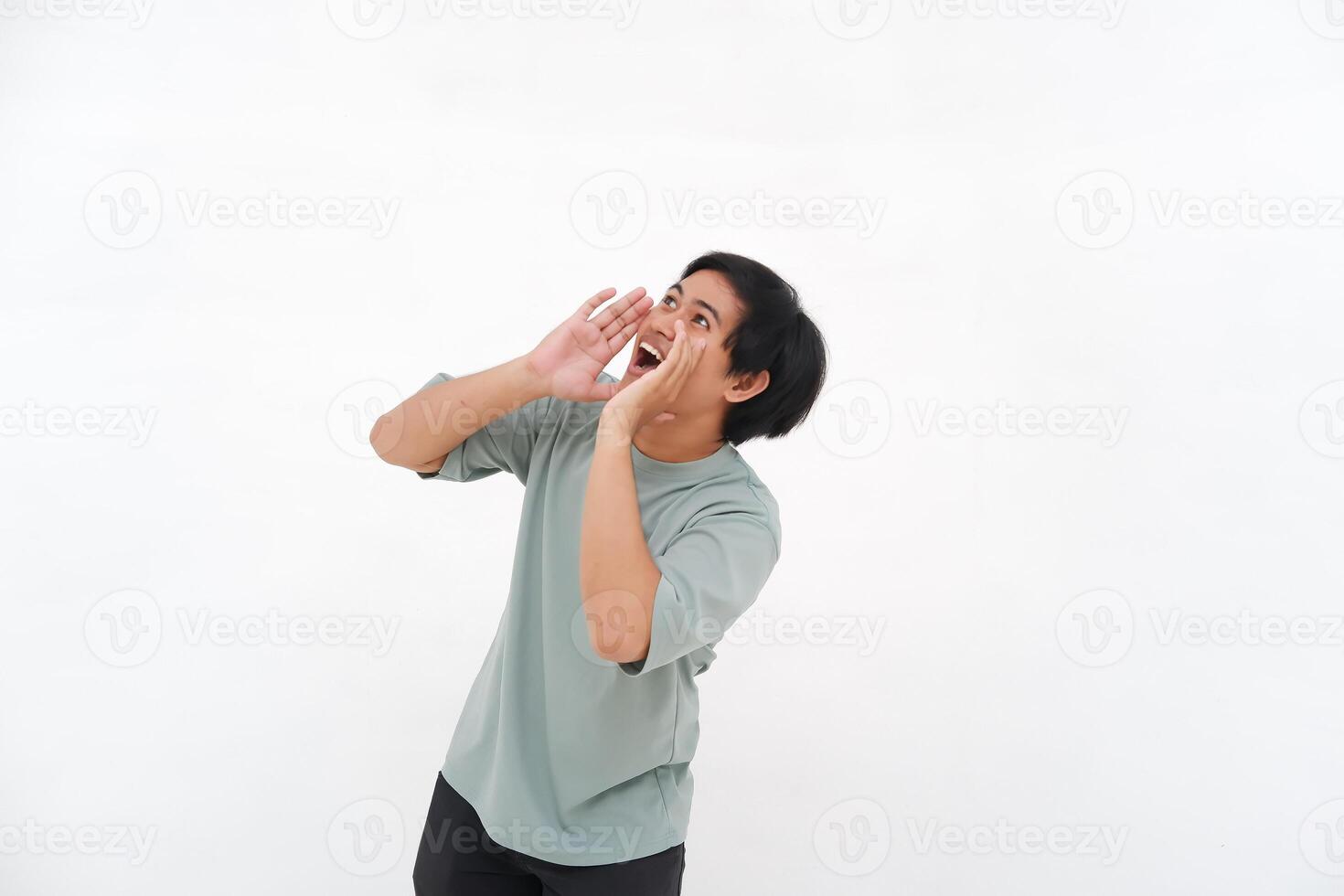 A young Asian man employee wearing tshirt is shouting and screaming loud with a hand on her mouth, isolated by white background. photo