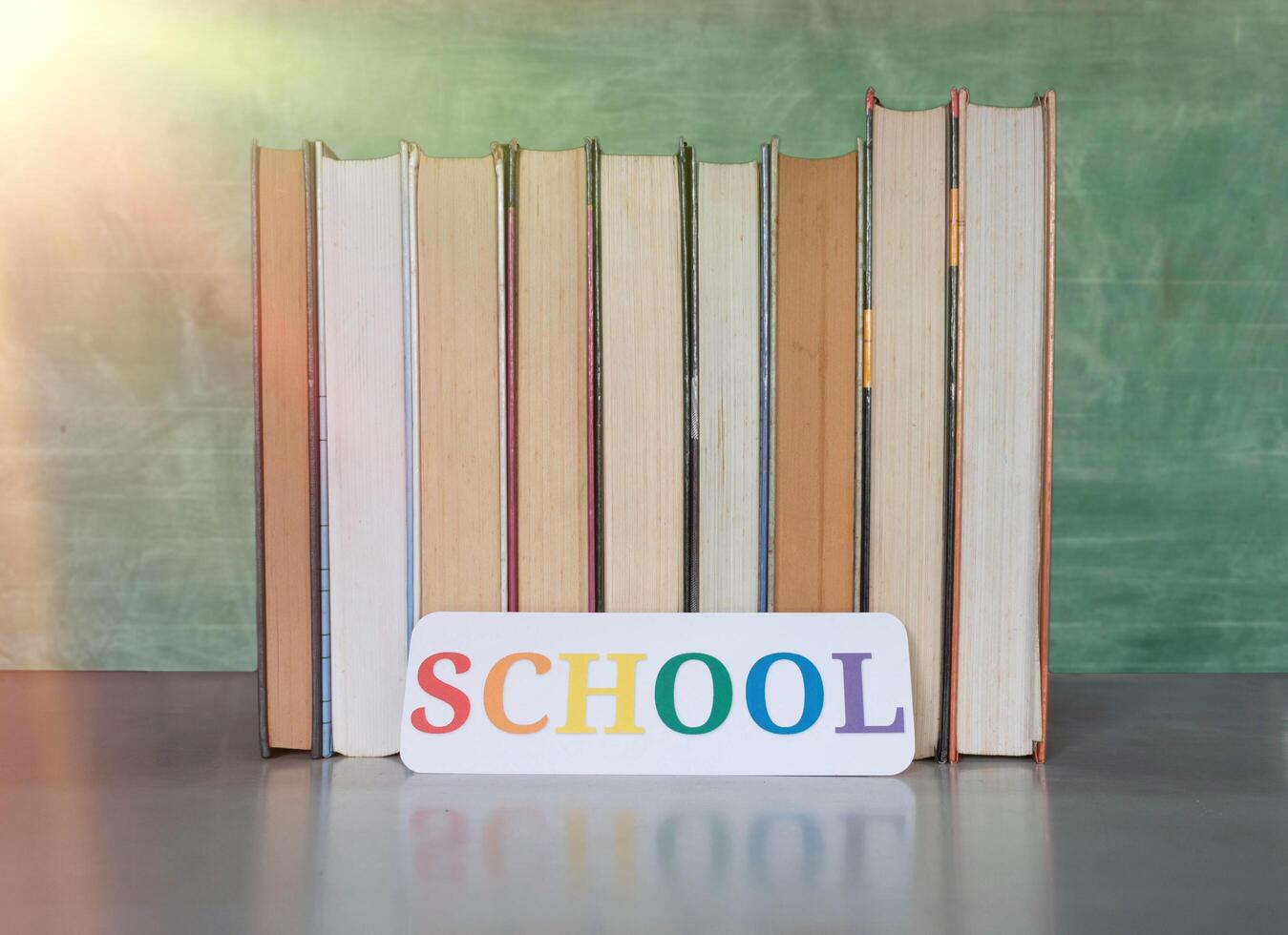 textbooks on desk in front of blurred blackboard photo