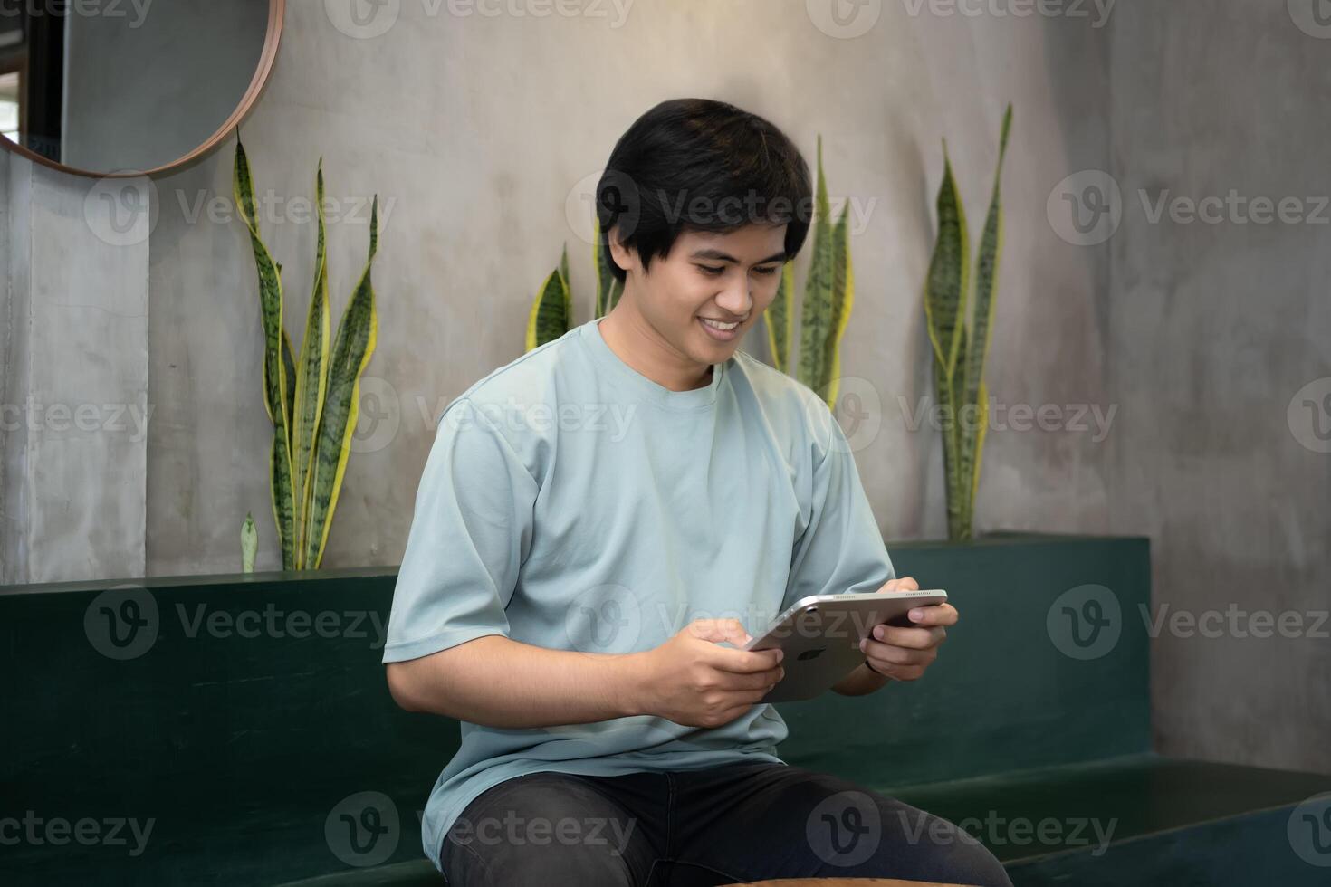 Potrait of Young Asian men holding a tablet PC in a cafe workplace with expressive faces photo
