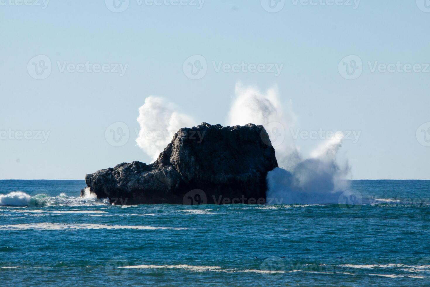Waves crashing into a rock photo