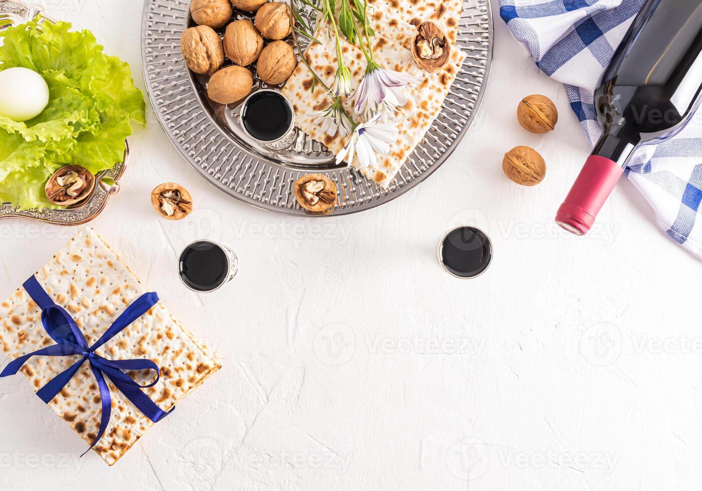 matzoth, red bottle of kosher wine, walnuts on a silver tray, herbs and egg. Traditional food for the celebration of the Jewish Passover. photo