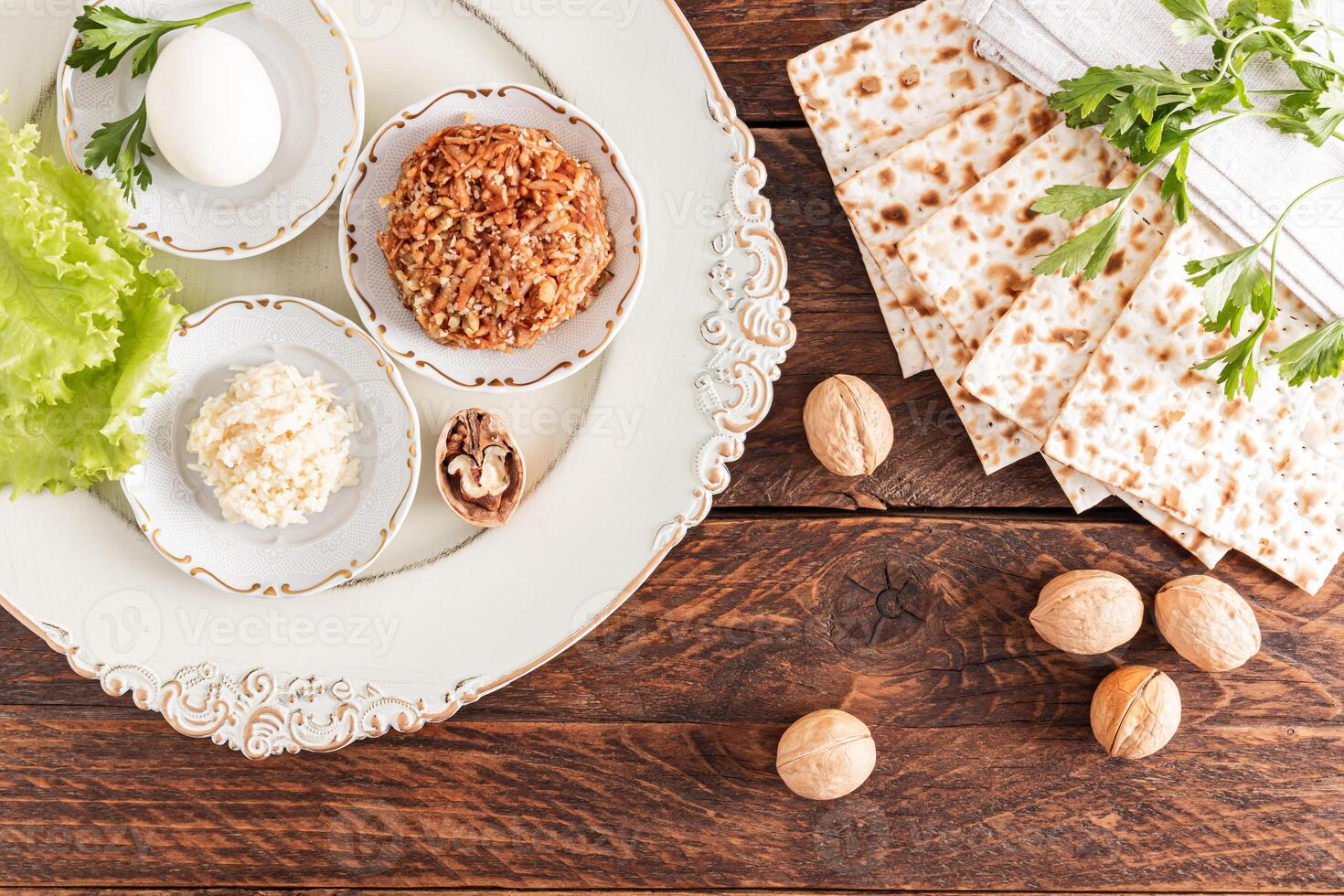 A beautiful dish with festive food for the Jewish Passover holiday. matzoth, nuts, lettuce, parsley, fruit paste. Top view. photo