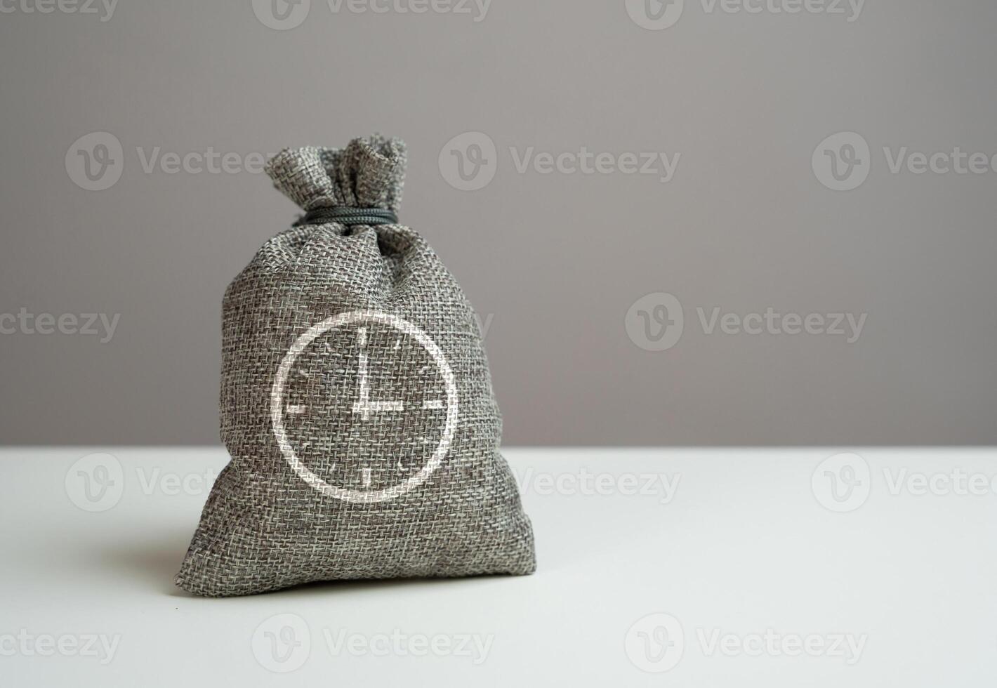 Money bag and symbol of time. A metaphor for time that can be used productively or invested. photo