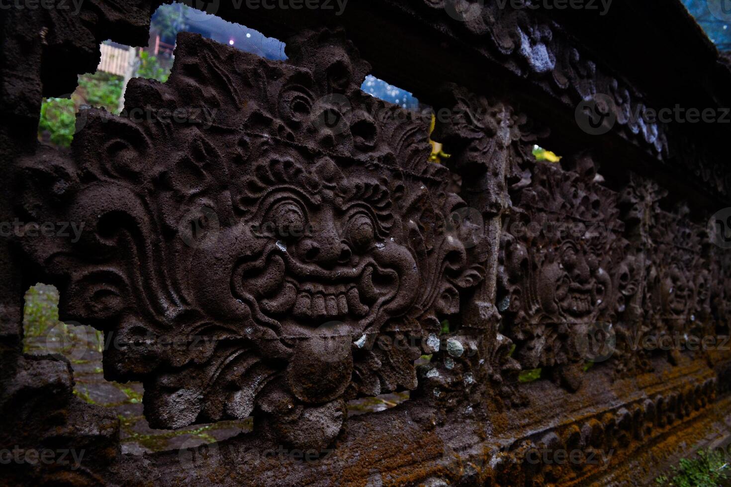 a carved stone temple fence with a carved face on it photo