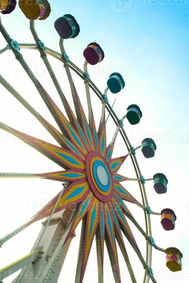 a colorful ferris wheel with a bright sky on top photo