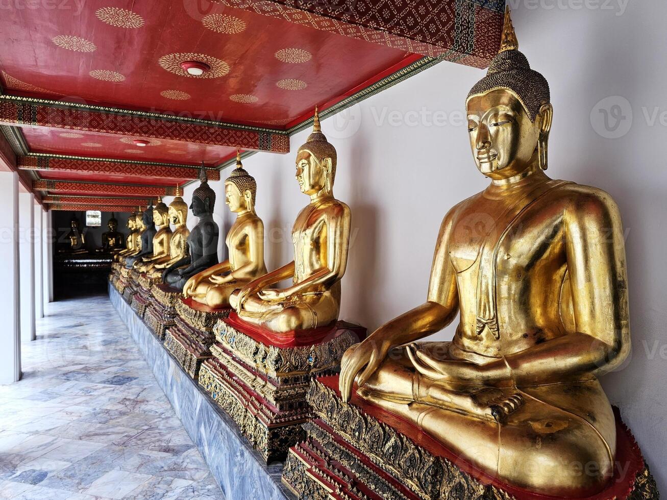 Golden Buddha Images at the hall way at Wat Pho Temple where is a Famous Temple and Historical Landmark of Bangkok Thailand, that Located beside Temple of the Emerald Buddha. photo