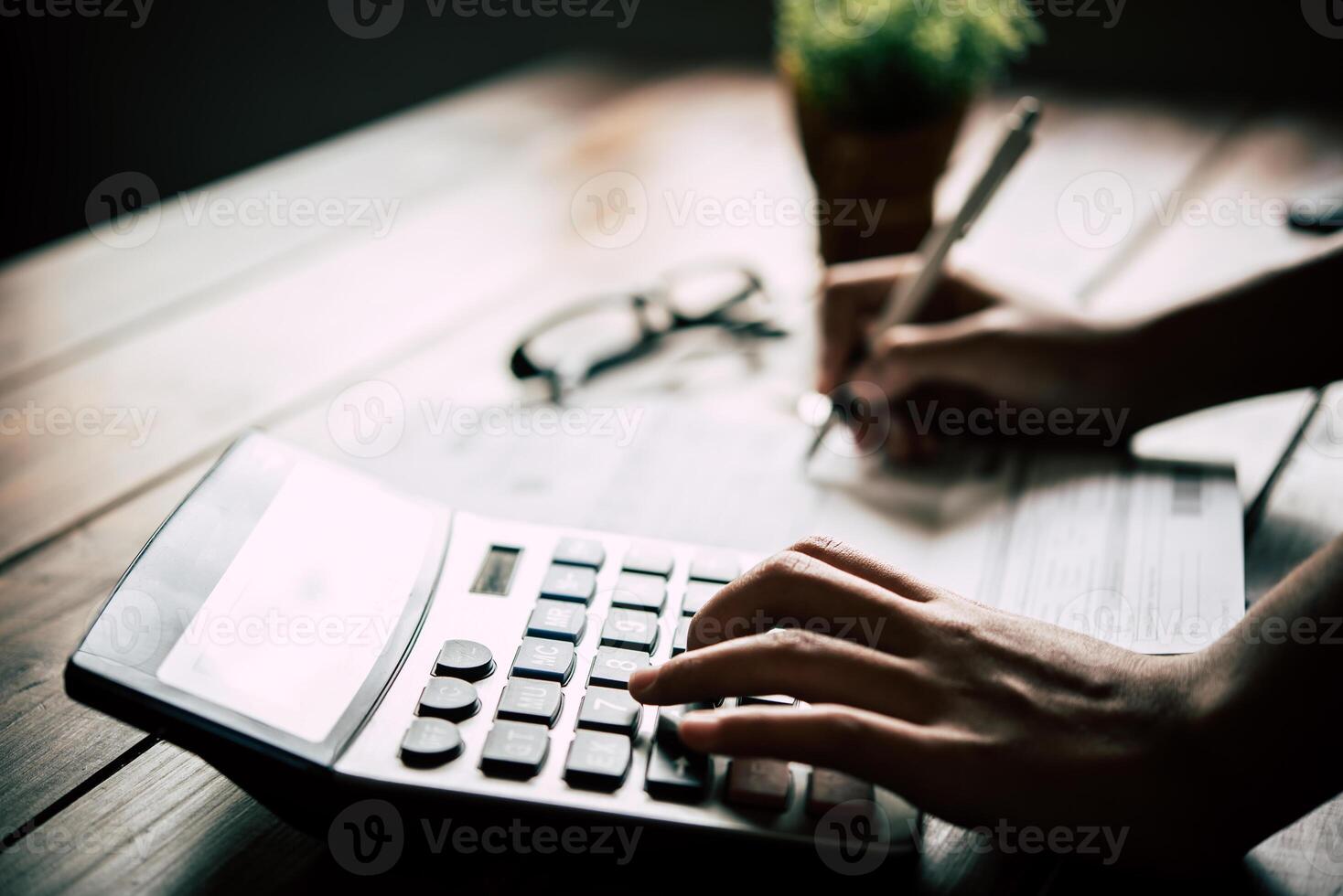 Businessmen are using a calculator to calculate the income of the business. photo
