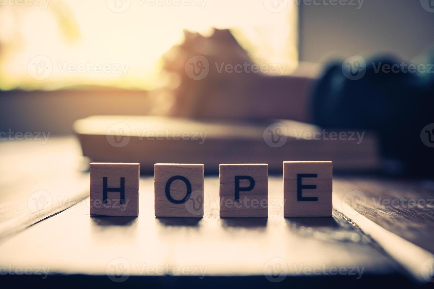 The letter  HOPE is placed on the table with Christians praying and praying to God in the back. photo