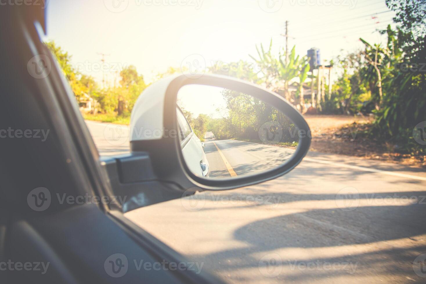 Rear-view mirror car in the reflection forest and long roadway photo