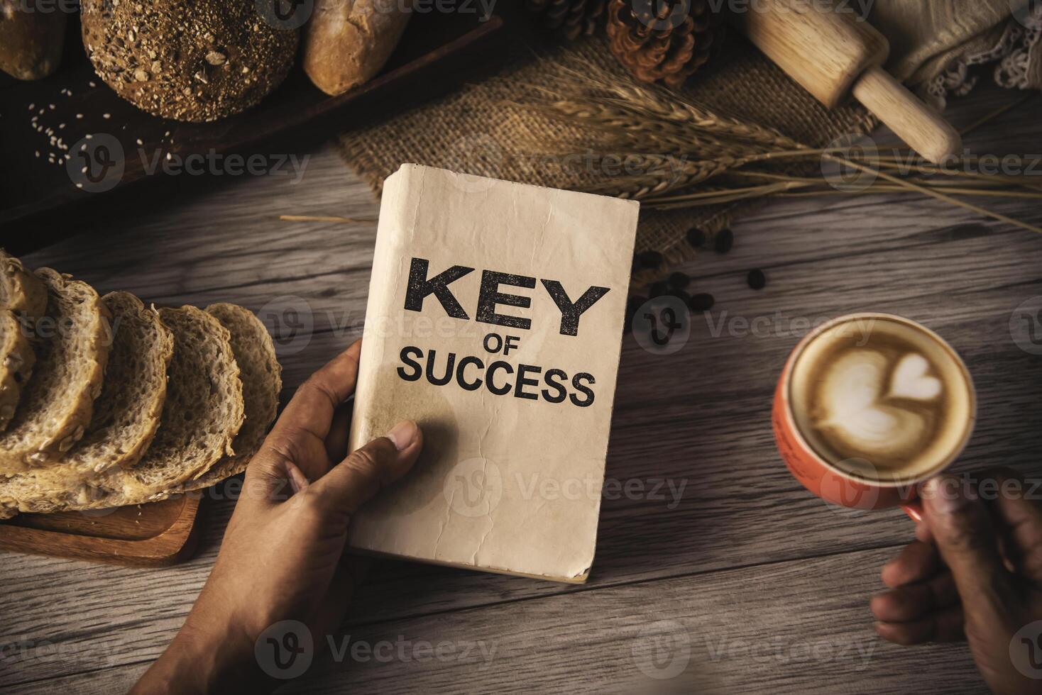 Hand holding a cup of coffee and reading a book key of success - concept lifestyle photo