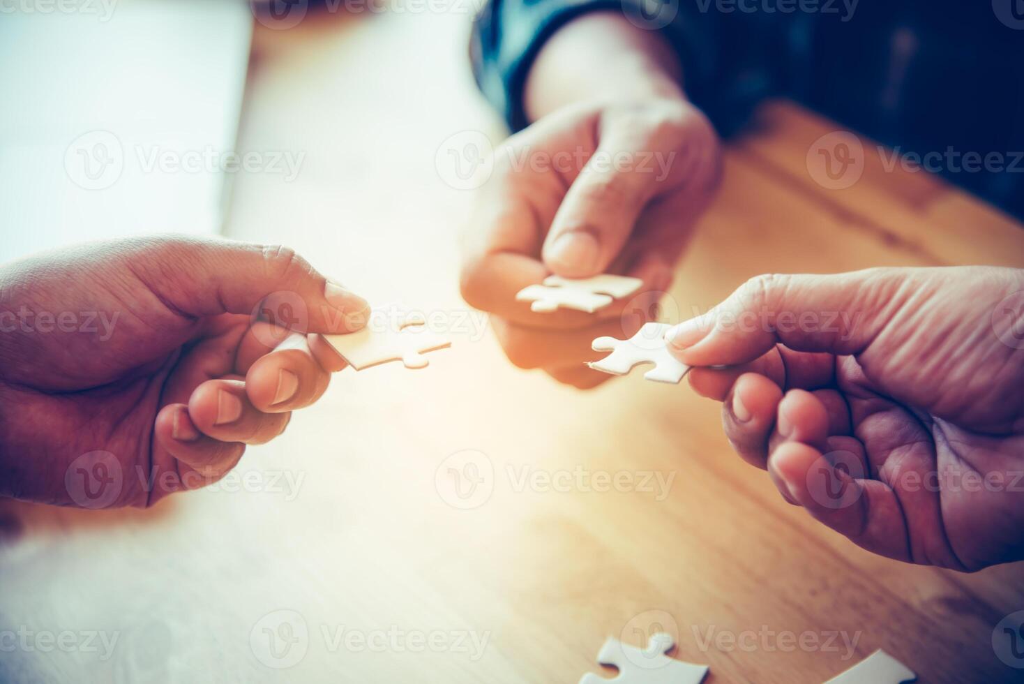 Business team handle a piece of white puzzles that are about to drop to get a complete worksheet - An attempt to succeed. photo