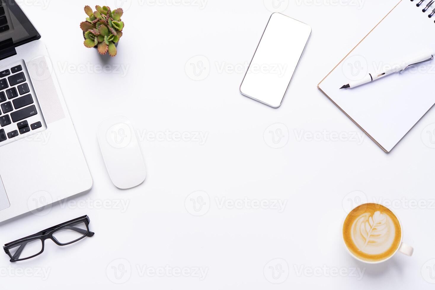 parte superior ver con trabajando escritorio con computadora portátil, teléfono celular, cuaderno lápiz café taza y los anteojos en el oficina. foto