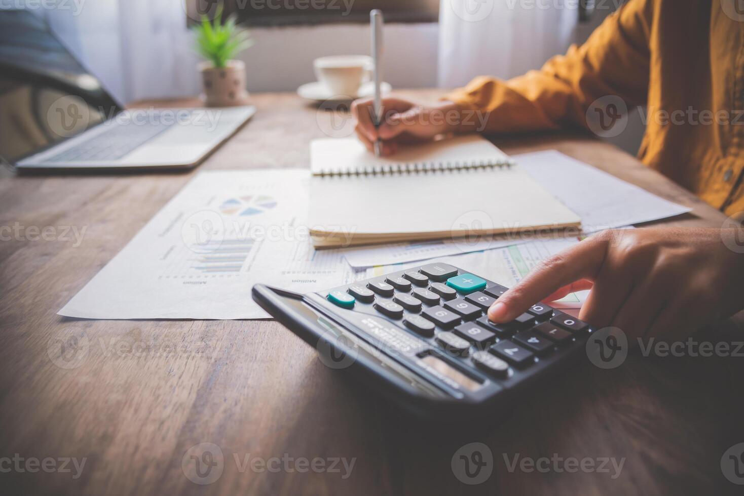 business person sitting at a desk at an office By using the calculator to work. Business Concept Analysis and Planning photo