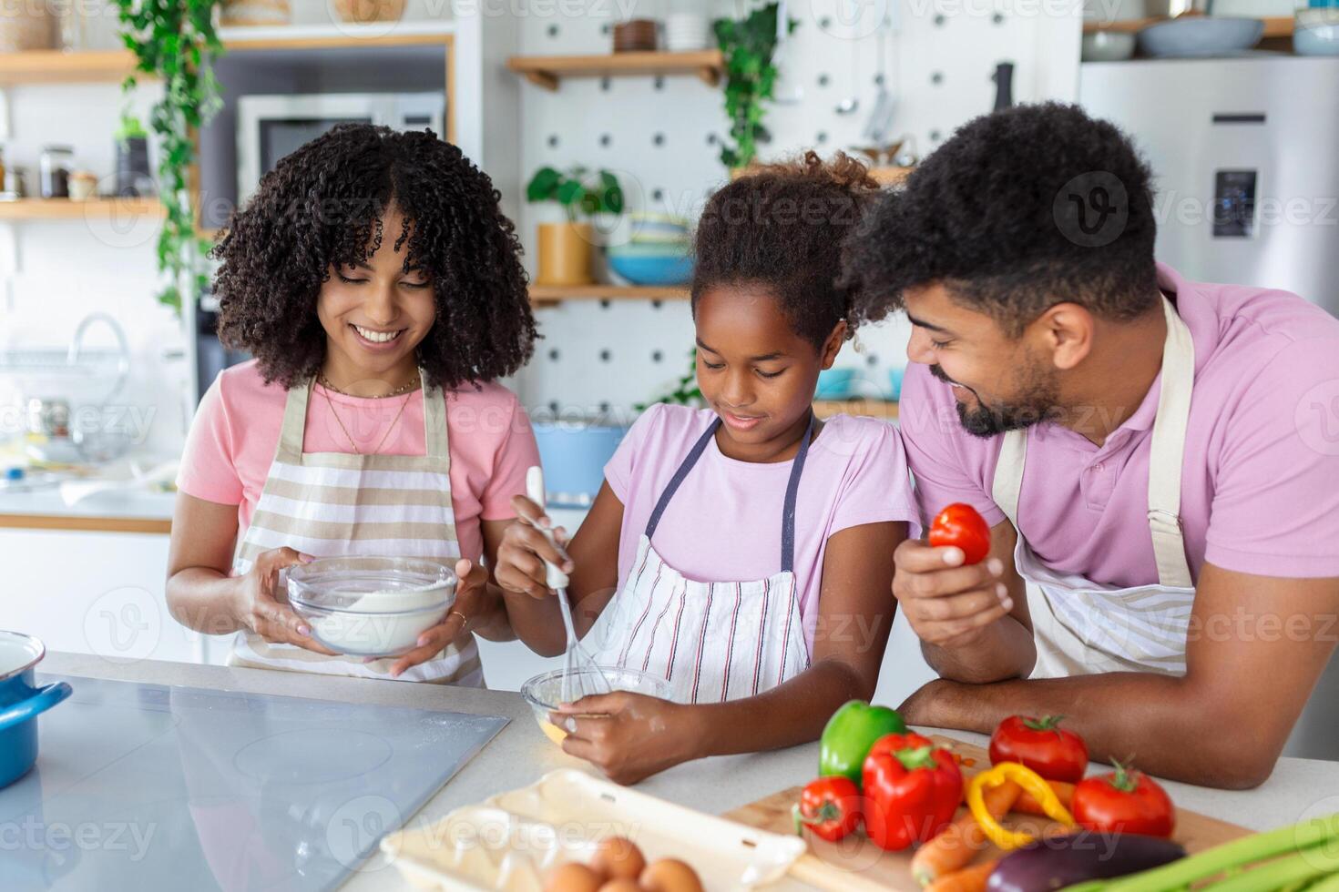 Happy family cooking together on kitchen. Mother and daughter with father cooking. Dad and daughter chopping green vegetable leaf for salad. Home recreation and food preparation on weekend photo