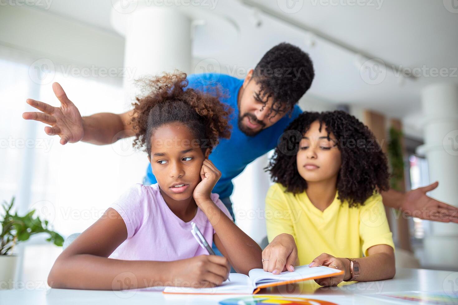 Parents yelling at their daughter while doing her homework at home. Young father and mother helping daughter study at living room. photo