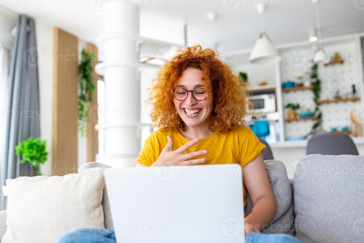 Happy young woman having fun doing video call using laptop in her home, waving hand video conference calling on laptop computer sit on sofa distance learn zoom online virtual meeting at home. photo