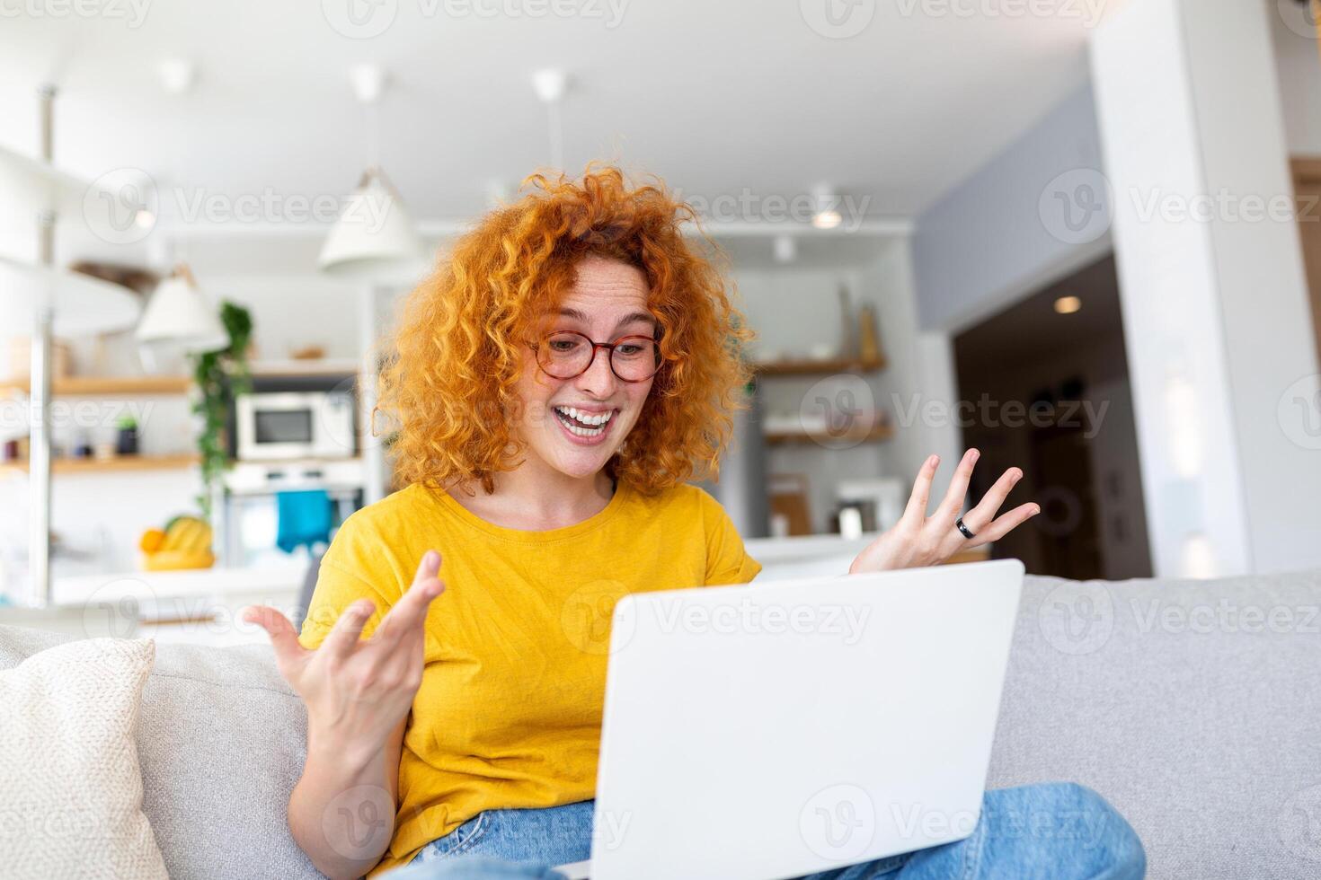 Happy young woman having fun doing video call using laptop in her home, waving hand video conference calling on laptop computer sit on sofa distance learn zoom online virtual meeting at home. photo