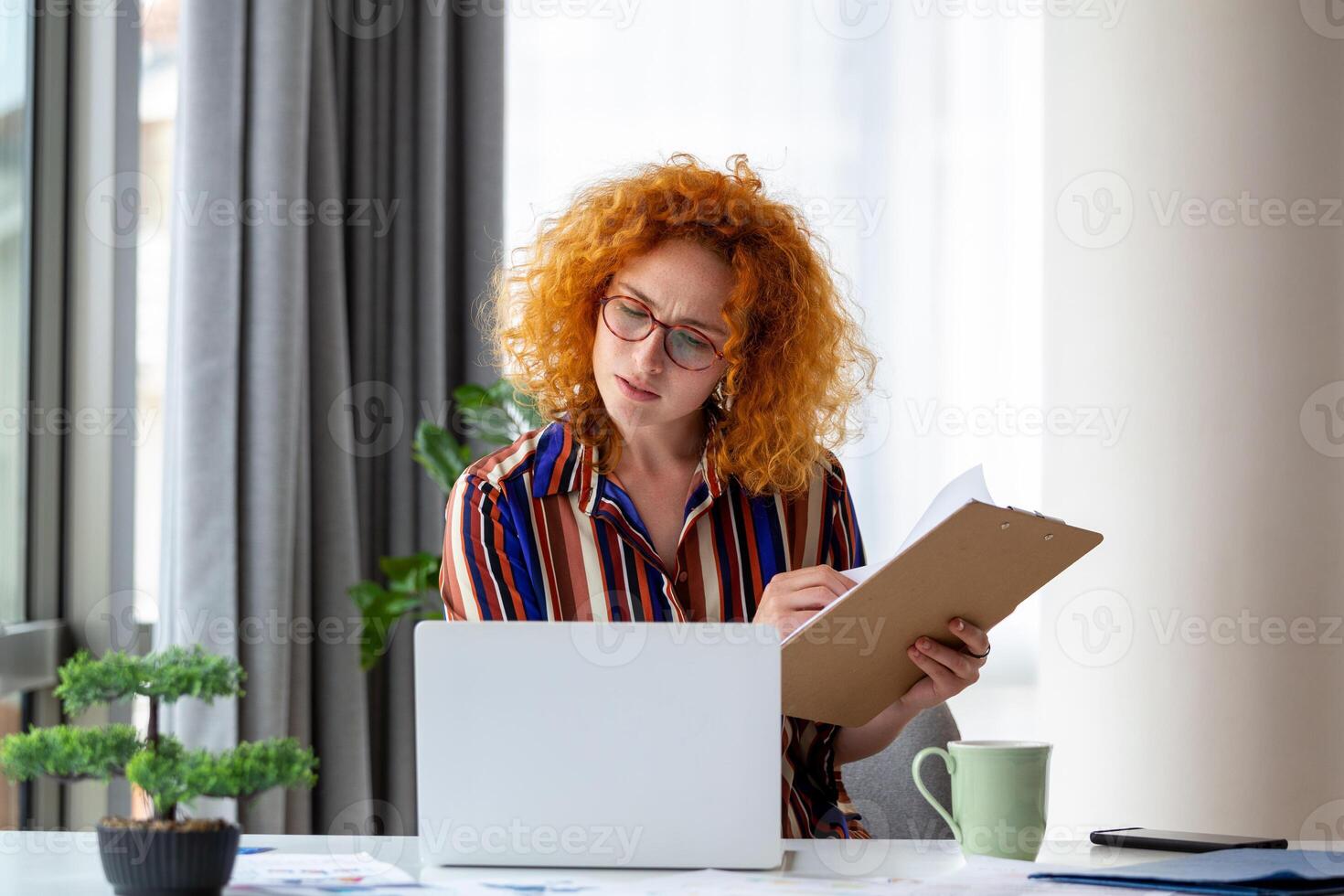 Focused business woman presenting charts and graphs on video call online. Young business woman having conference call with client on laptop. Young woman explaining how business work photo