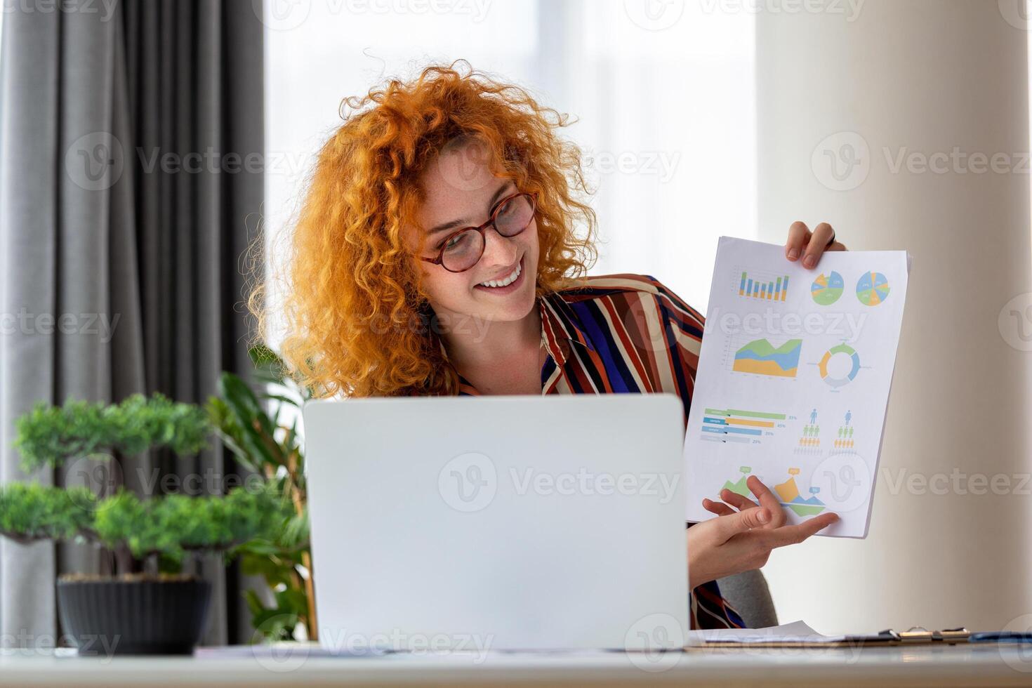 Focused business woman presenting charts and graphs on video call online. Young business woman having conference call with client on laptop. Young woman explaining how business work photo