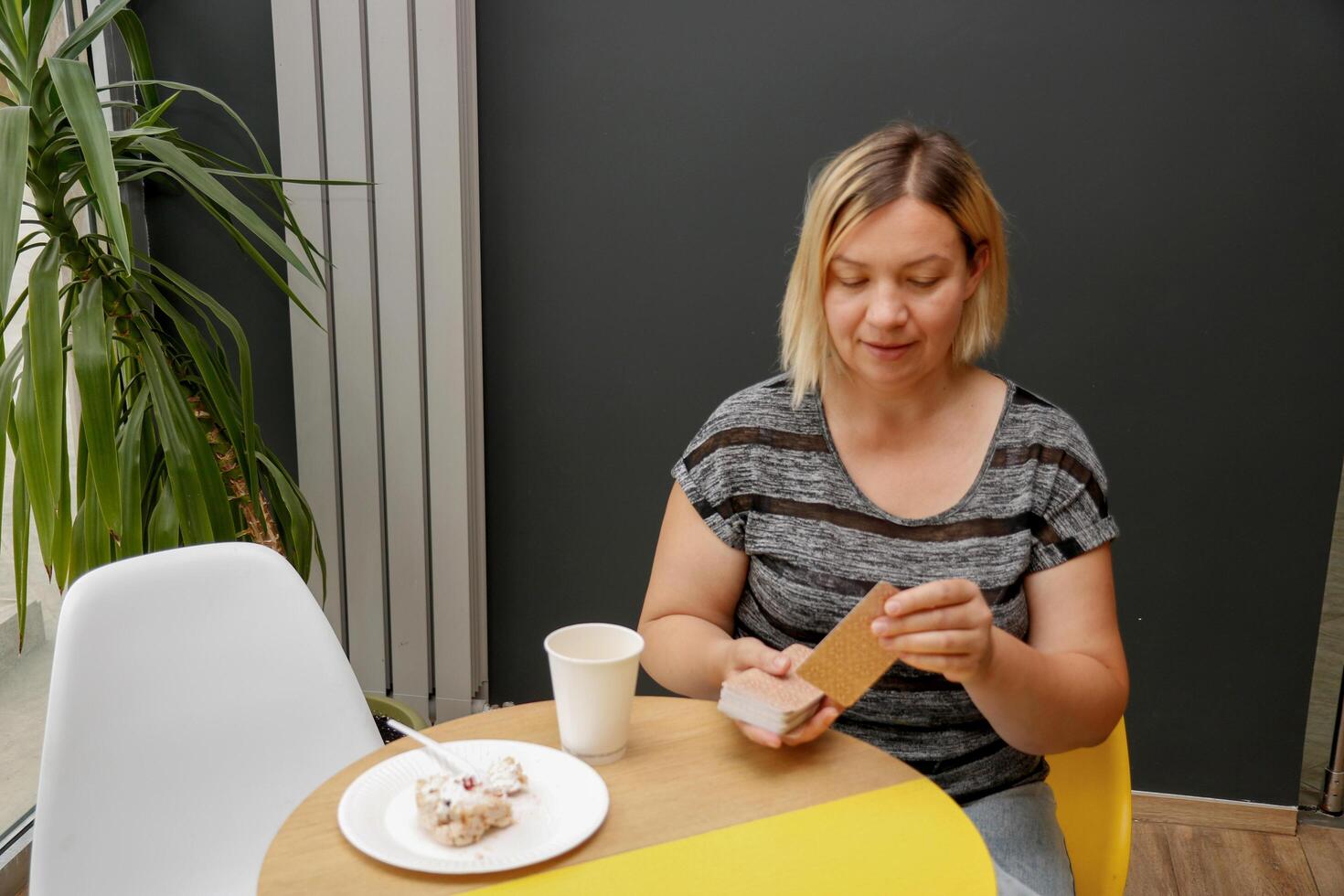 woman at a cafe table laying out tarot cards photo