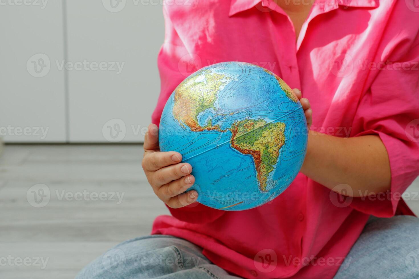 woman holding a physical globe in her hands photo