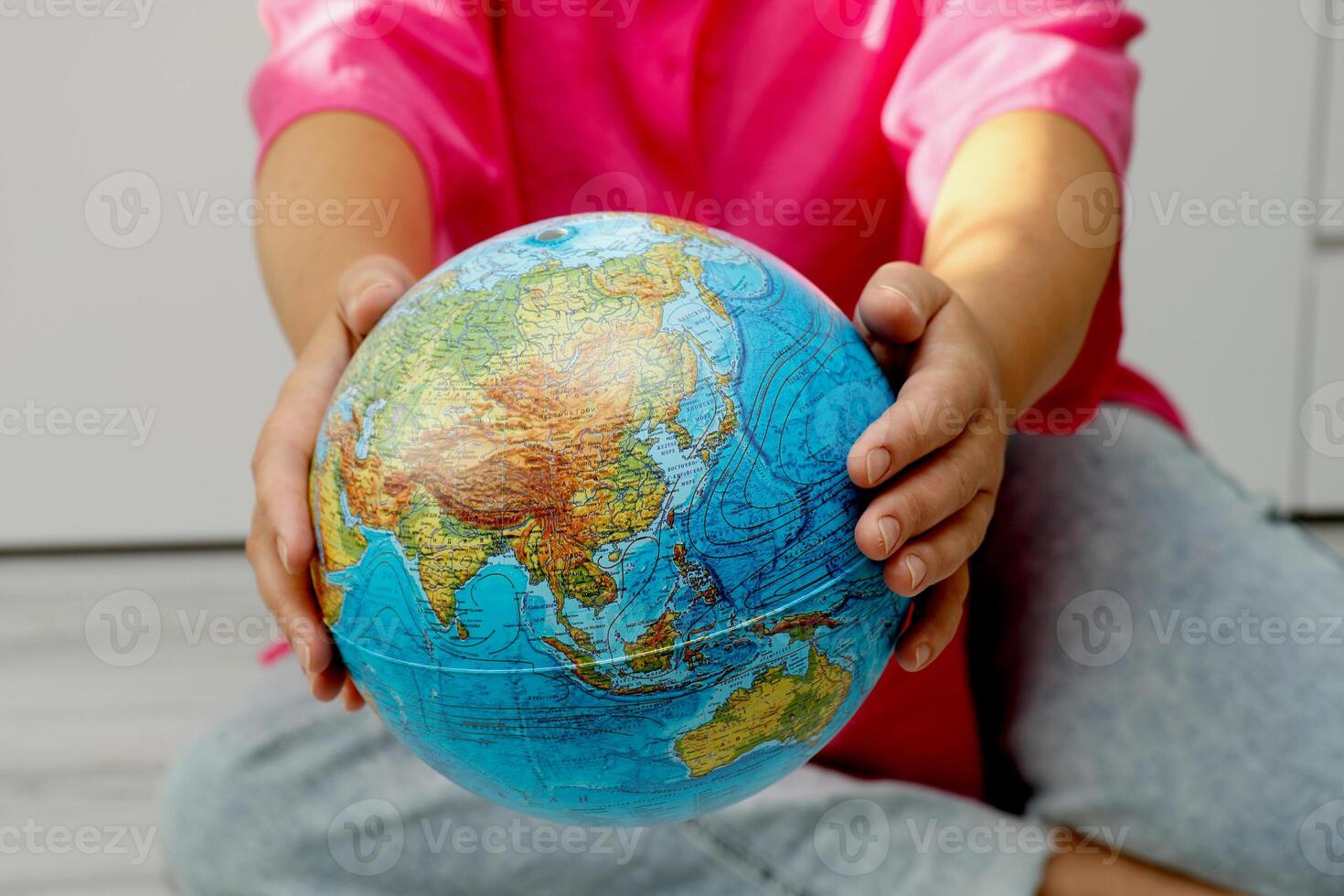 woman holding out physical globe photo