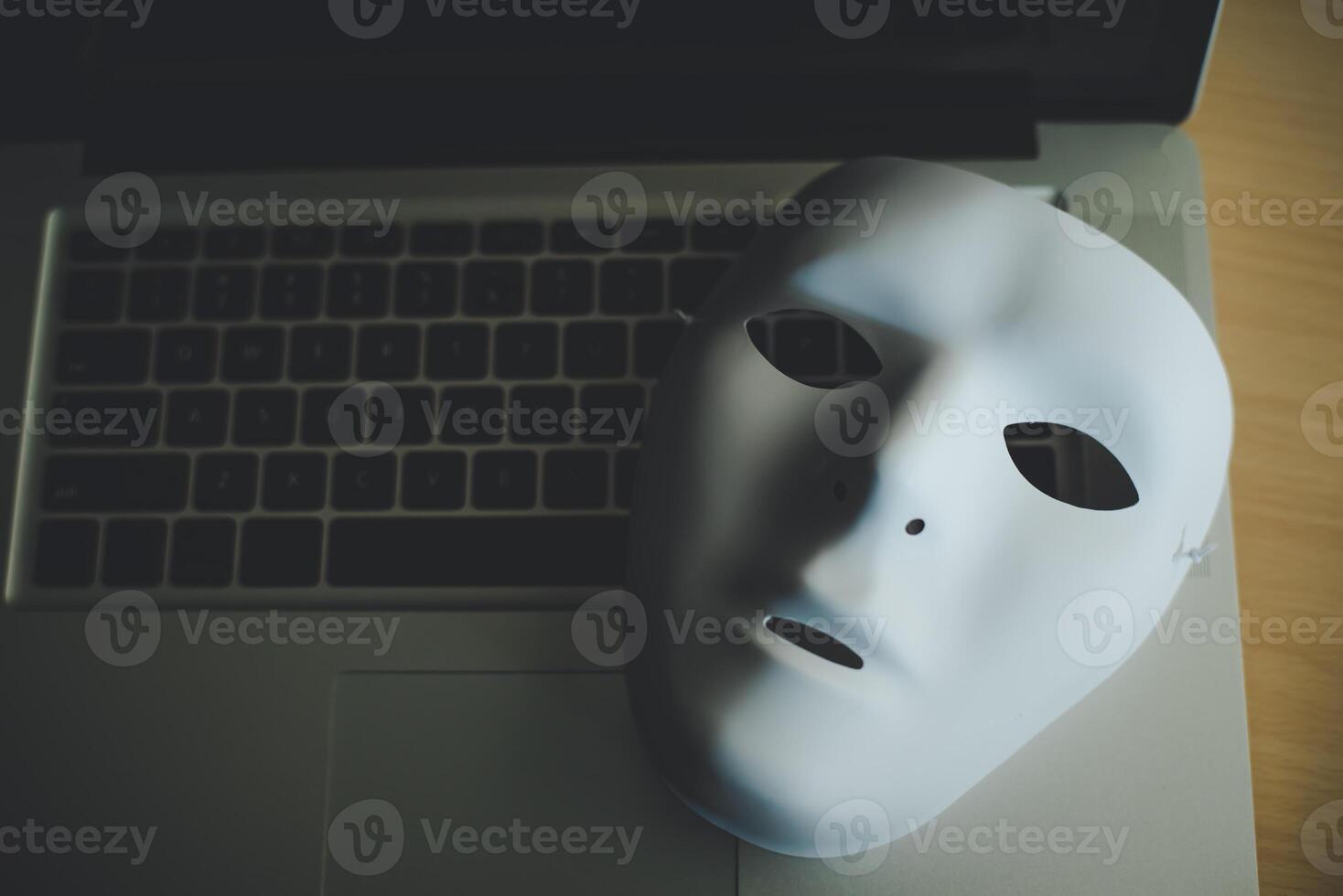 White mask placed on the laptop - concept fraud of social online photo