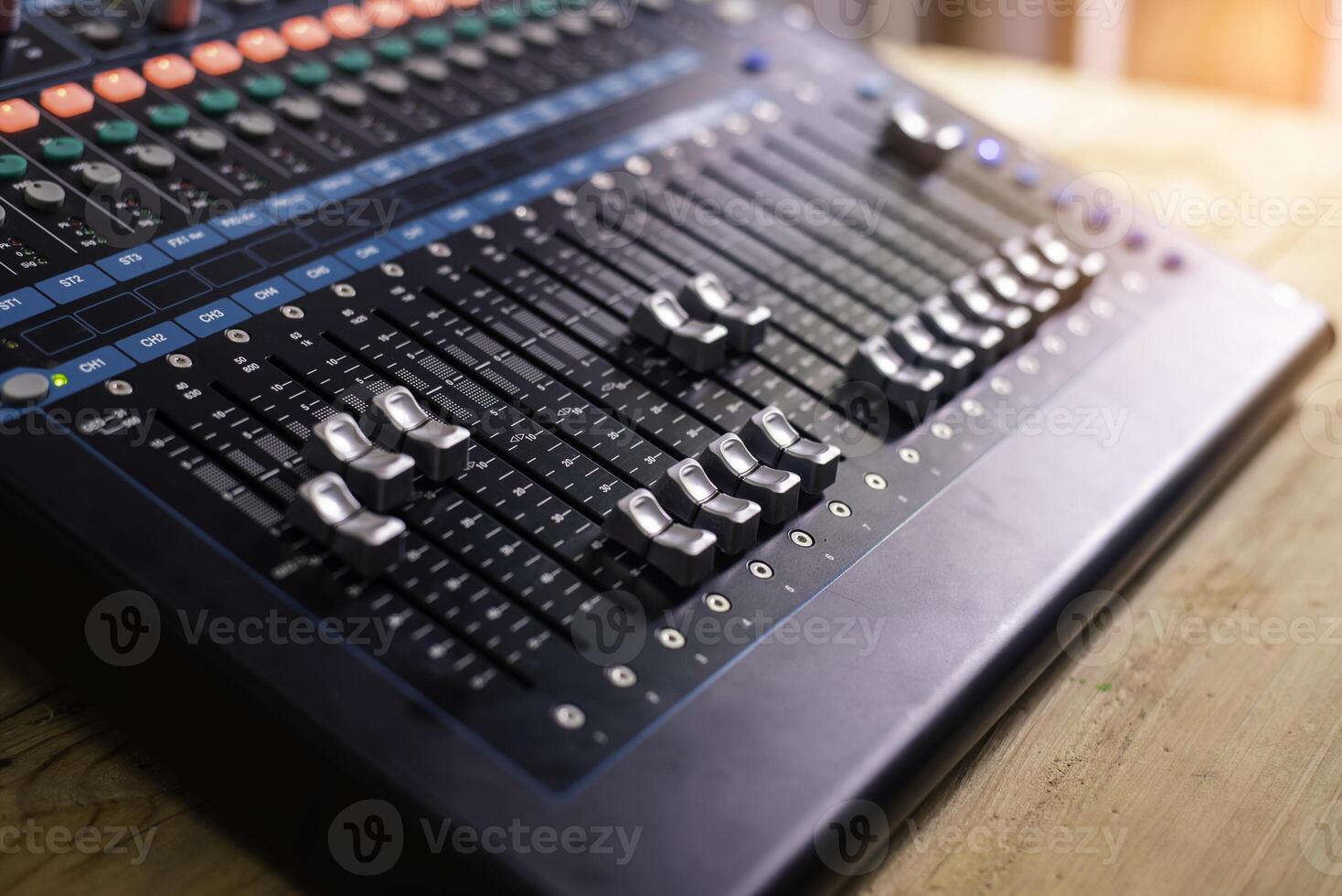 The DJ is adjusting the volume of the sound. Professional audio mixing console photo