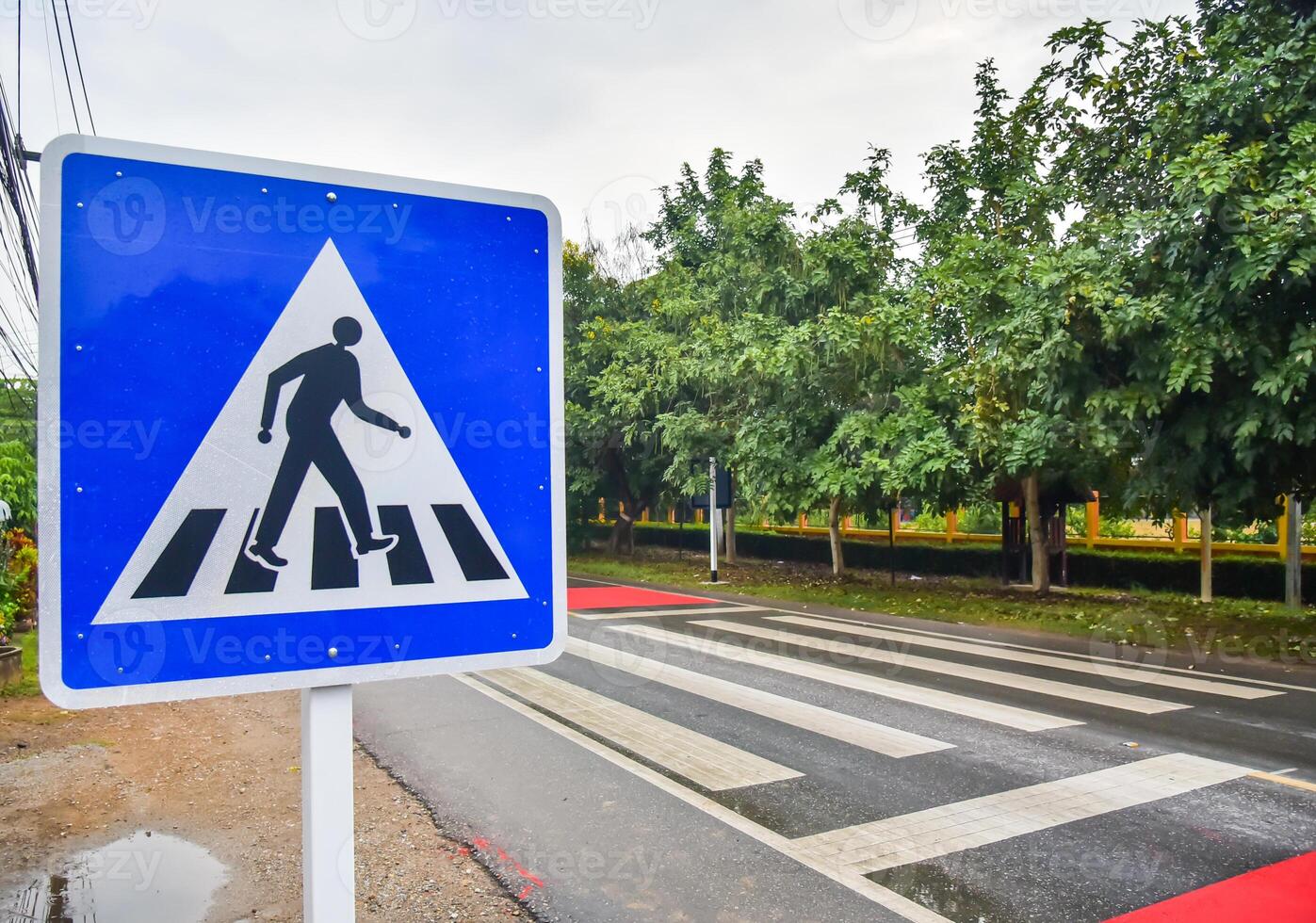 Crosswalk sign on the road for safety when people walking the street photo